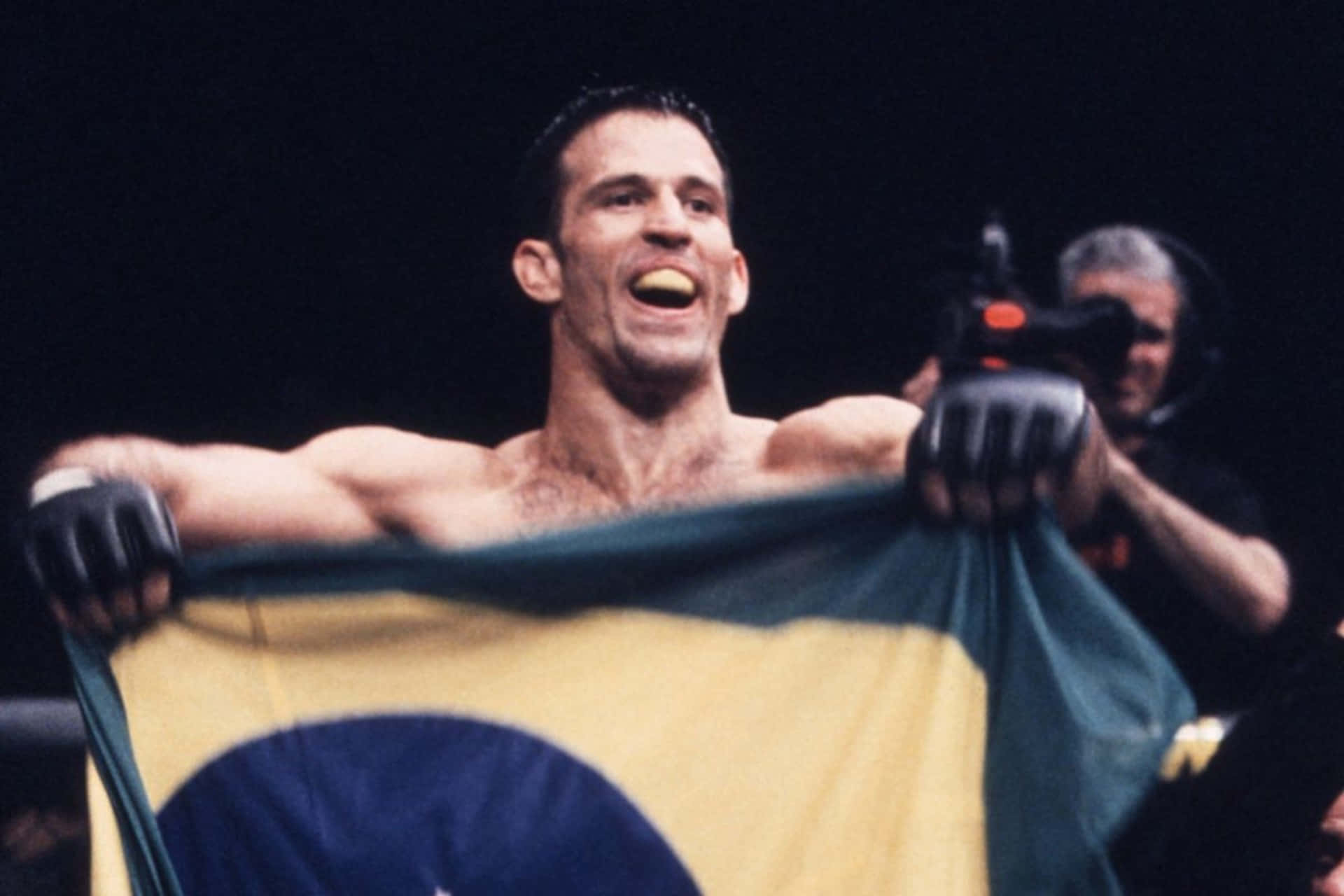 Murilo Bustamante Brandishing The Brazilian Flag Background