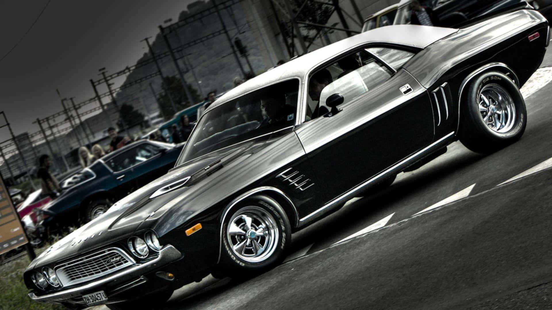 A Black And White Muscle Car Is Parked On The Street