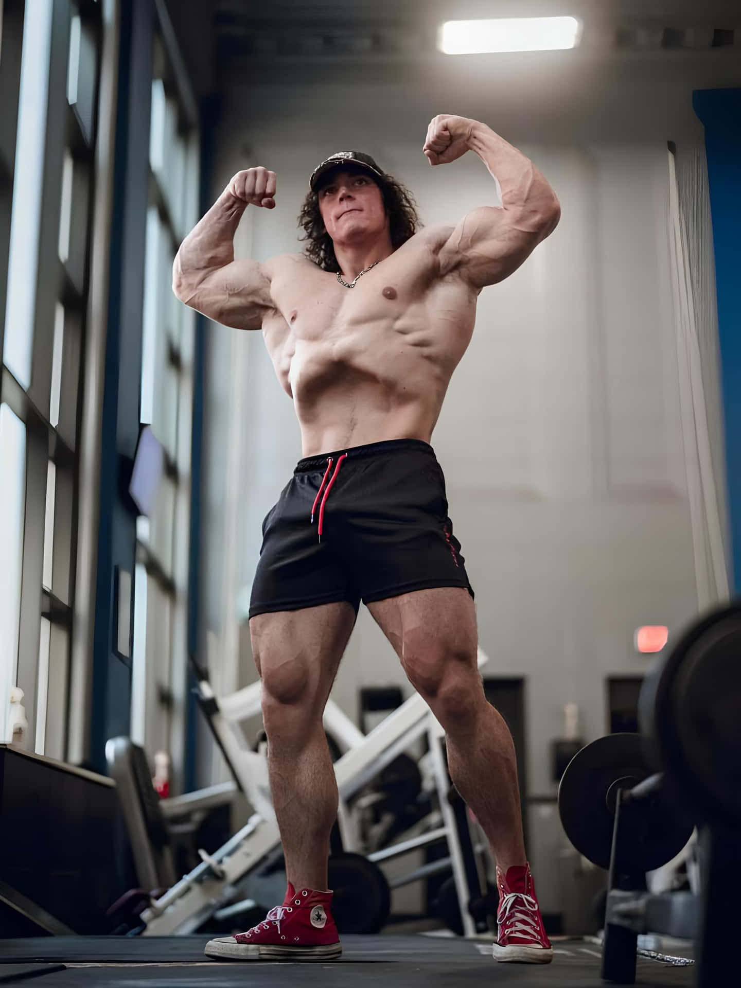 Muscular Man Flexing Biceps Gym Setting Wallpaper