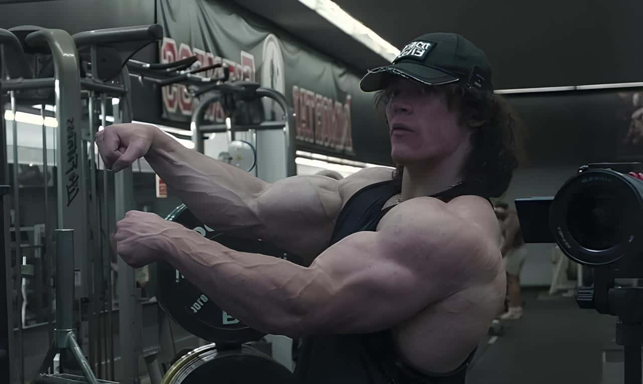 Muscular Man Flexing Bicepsin Gym Wallpaper