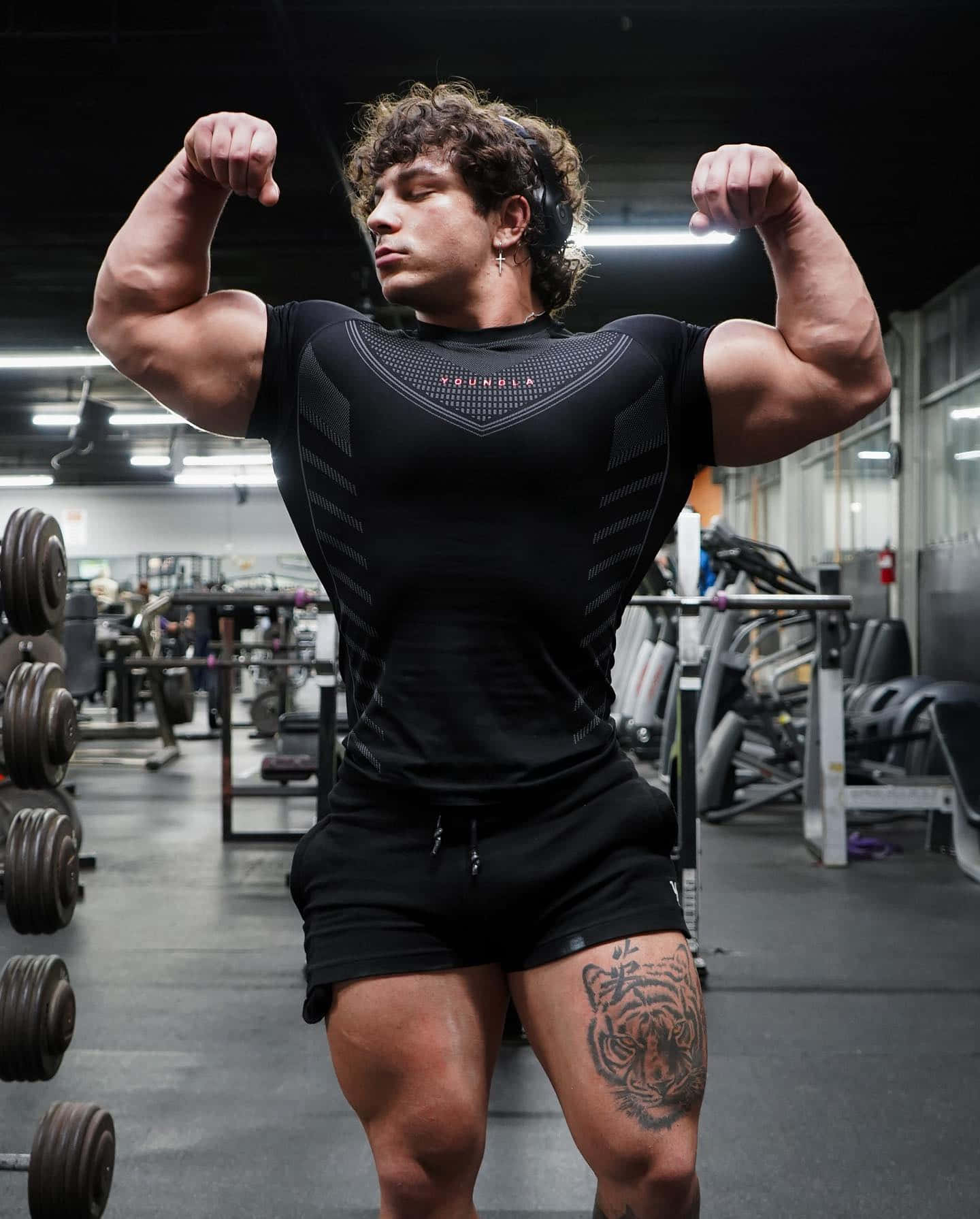 Muscular Man Flexing Bicepsin Gym.jpg Wallpaper