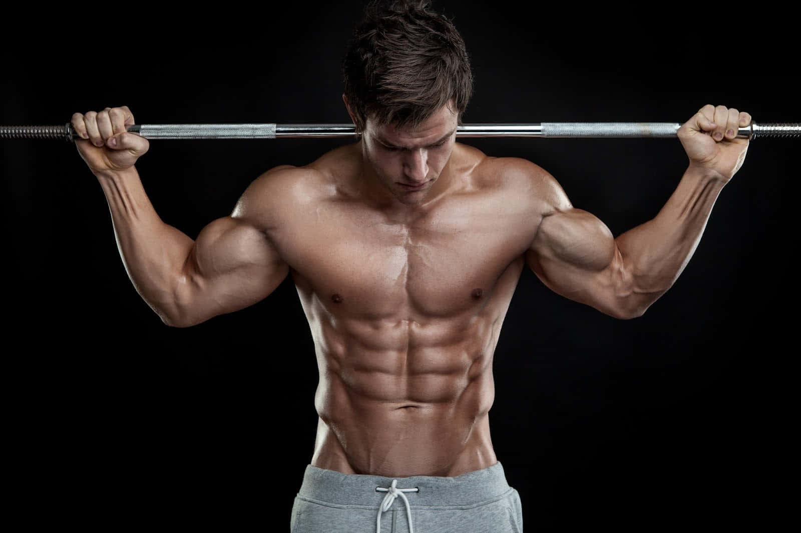 Muscular Man Performing Barbell Curls Wallpaper