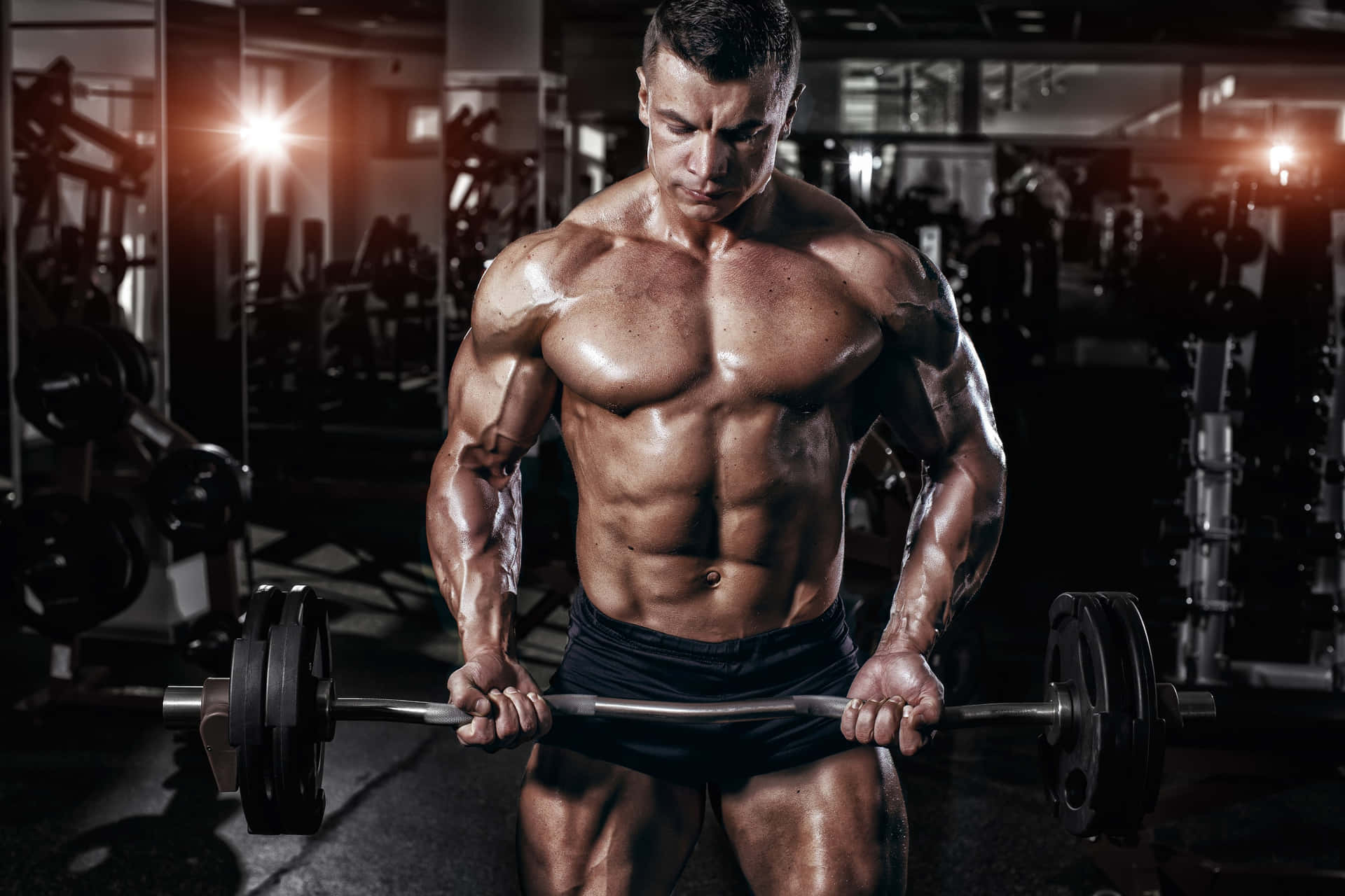Muscular Man Performing Bicep Curlsat Gym Wallpaper