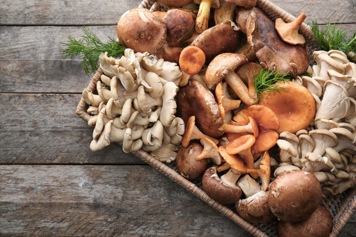 A Basket Of Mushrooms On A Wooden Table
