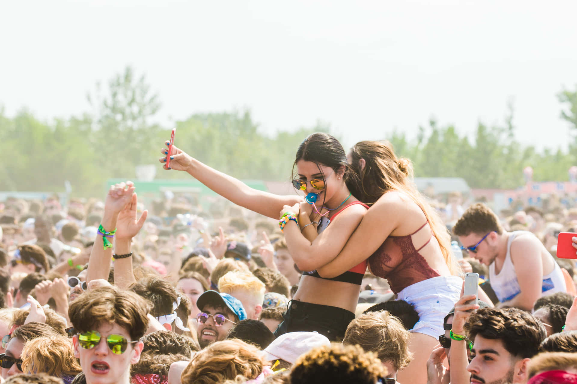 Excited Crowds Enjoying a Vibrant Music Festival Wallpaper