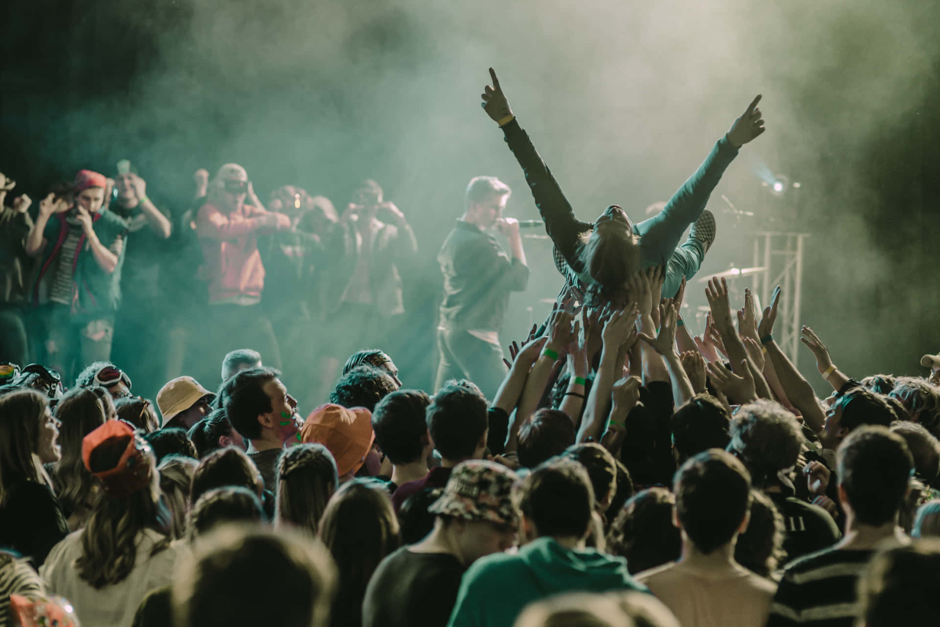 Energetic crowd enjoying a live performance at a music festival Wallpaper
