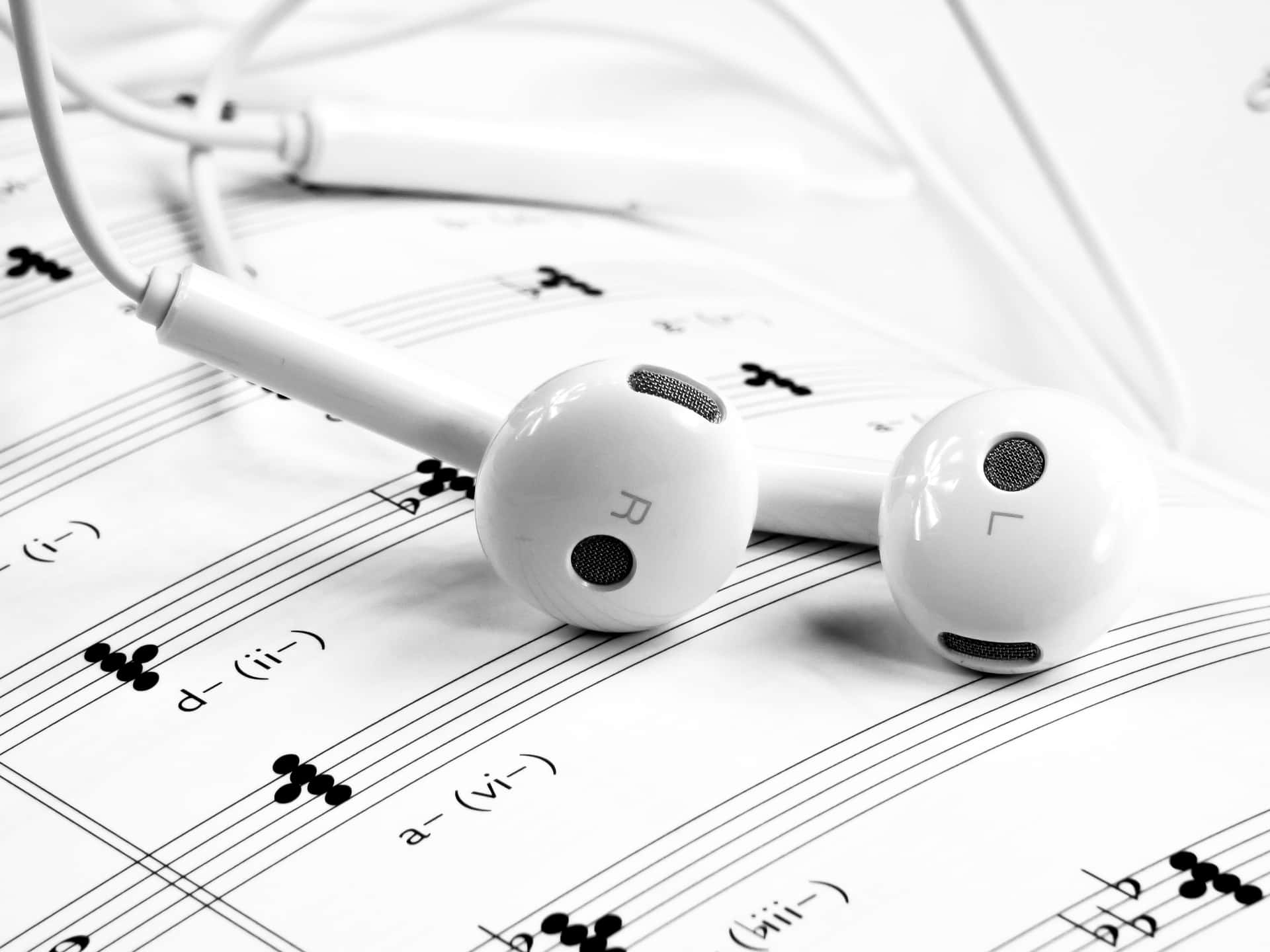 Earphones On Music Sheet With Music Notes Wallpaper