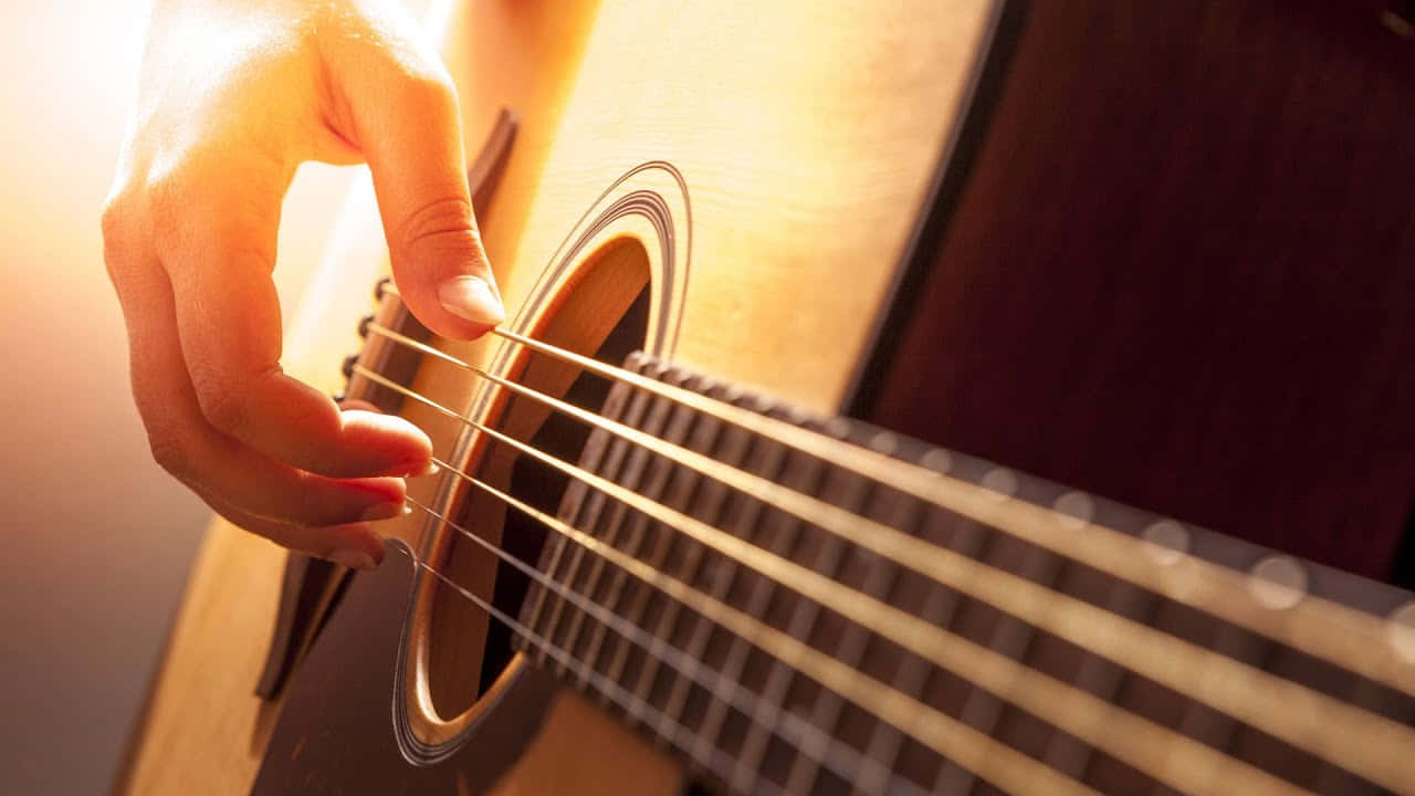 Imagende Una Mano Tocando Una Guitarra Acústica, Instrumento Musical.