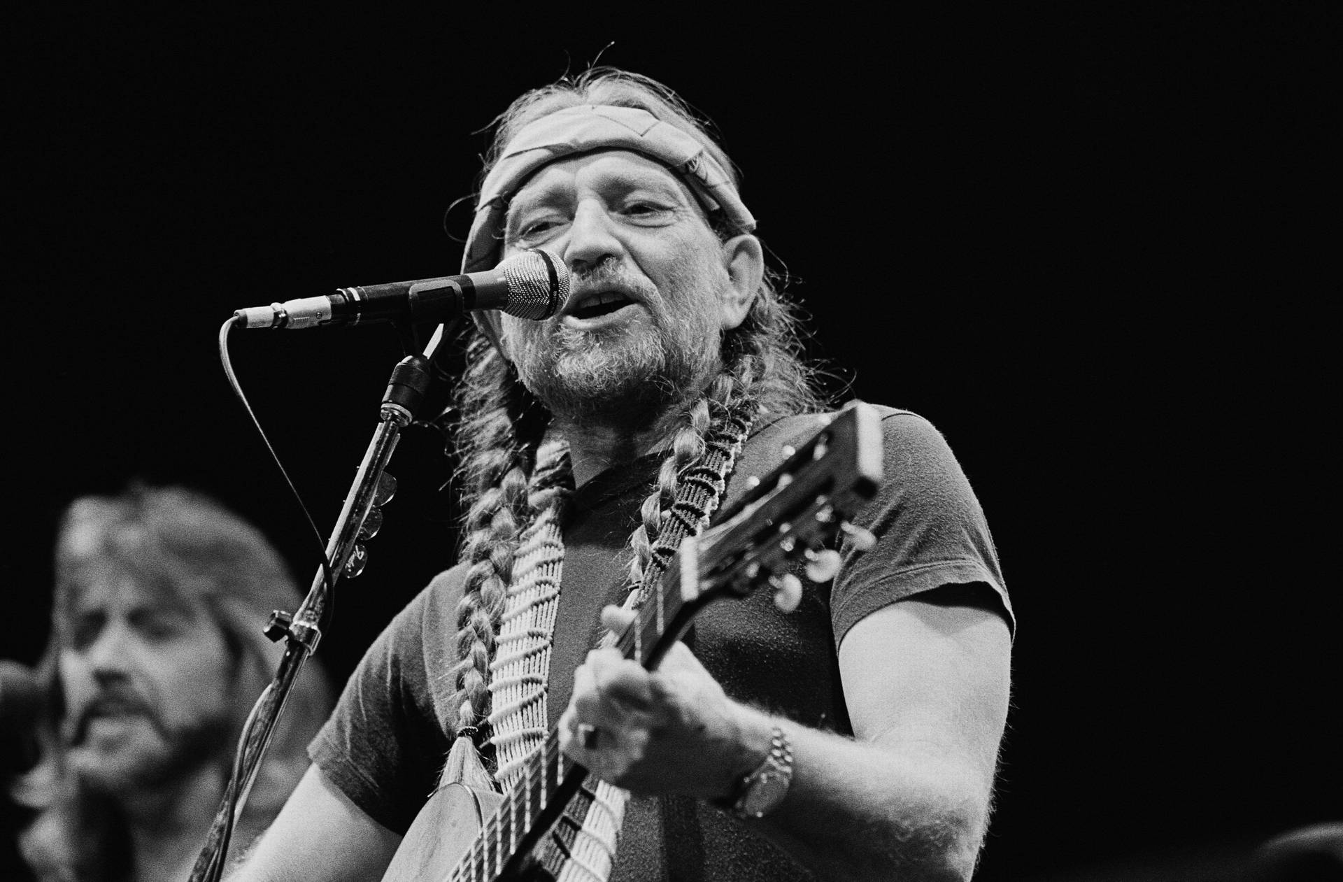 Musician Willie Nelson Performing On Stage Wallpaper