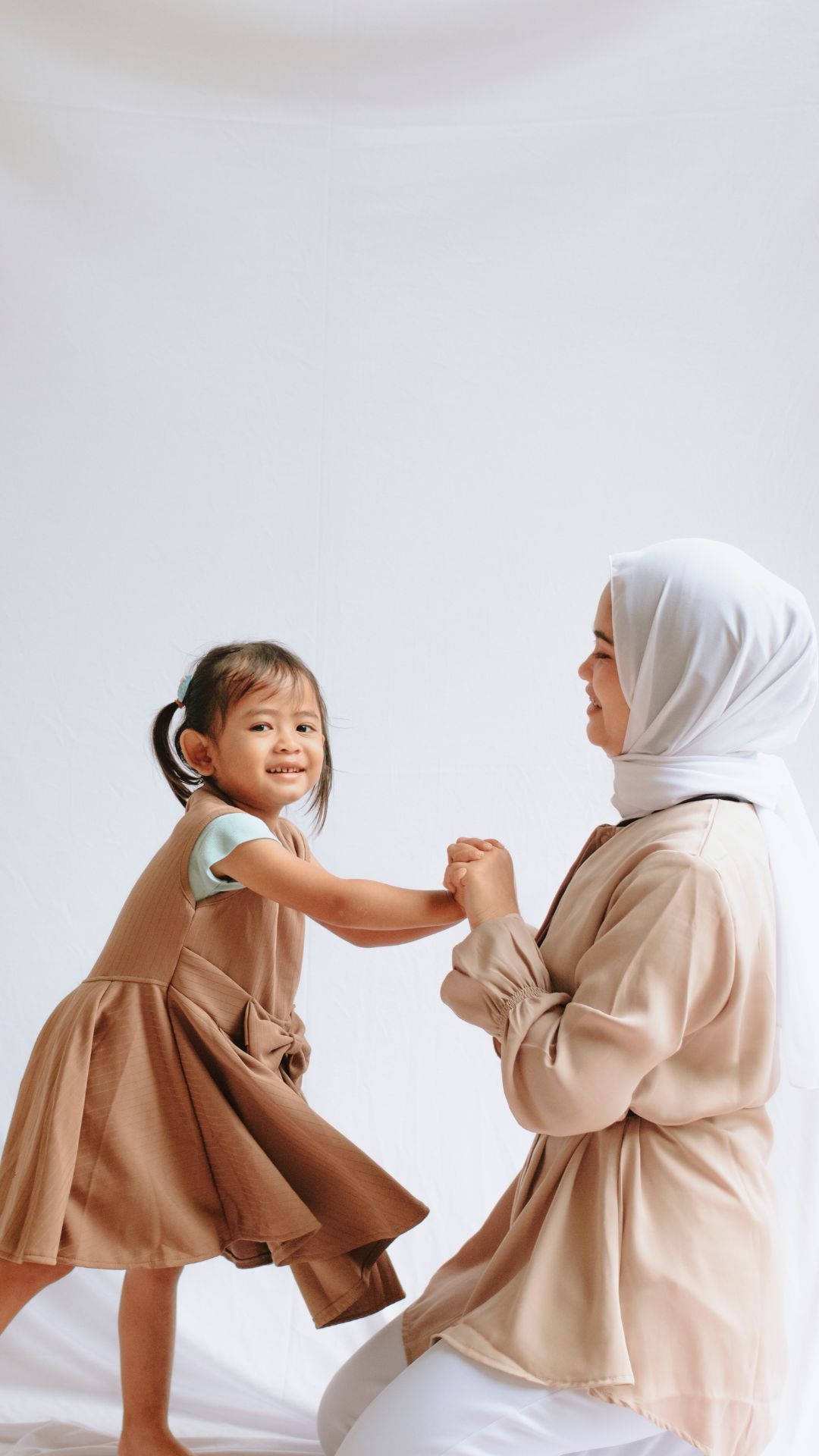 Muslim Mor Holder Hænder med hendes datter i Solskin Wallpaper