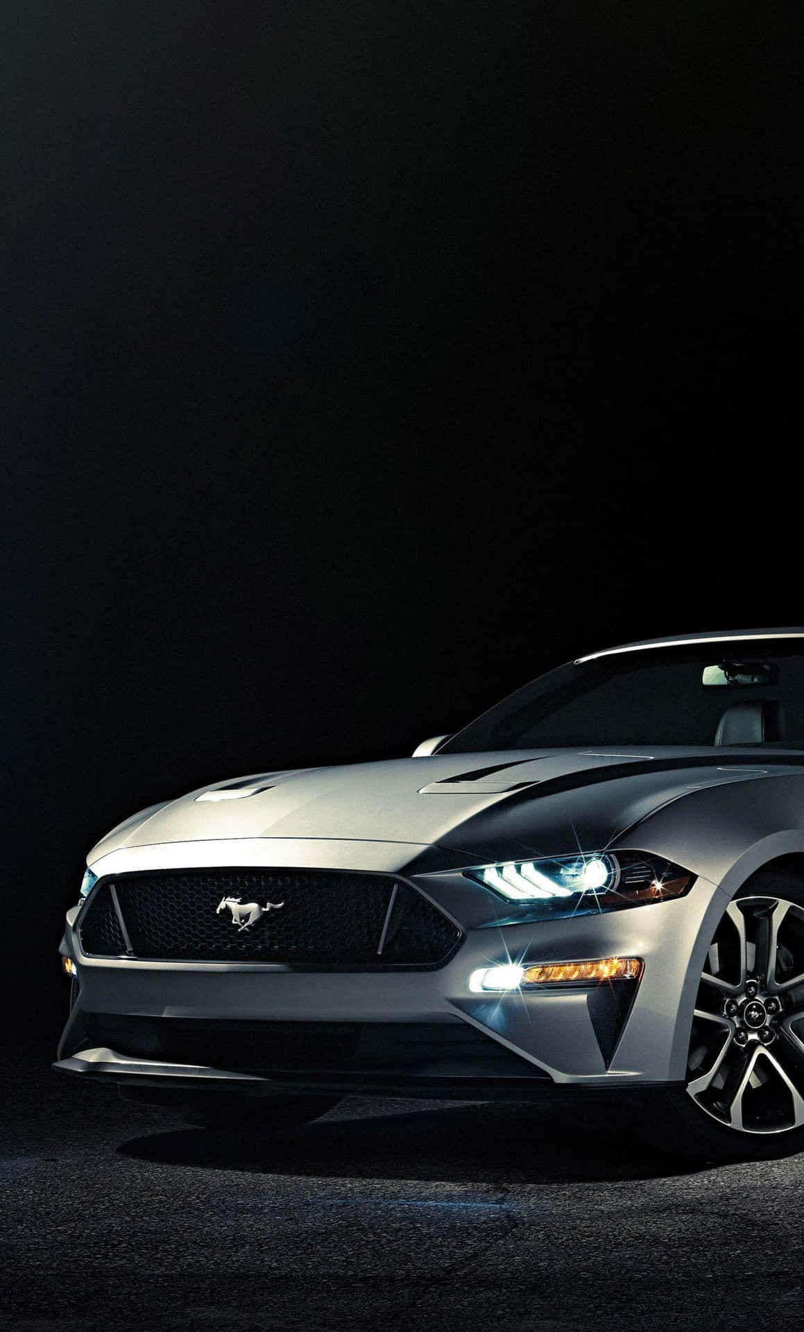 Den 2019 Ford Mustang er vist i et mørkt rum. Wallpaper