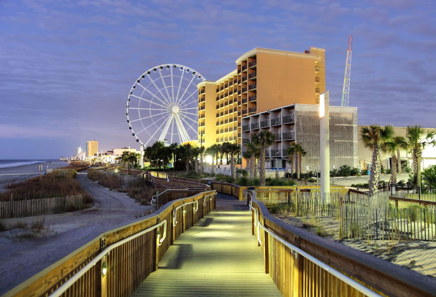 A Walkway Leading To The Beach And Ferris Wheel