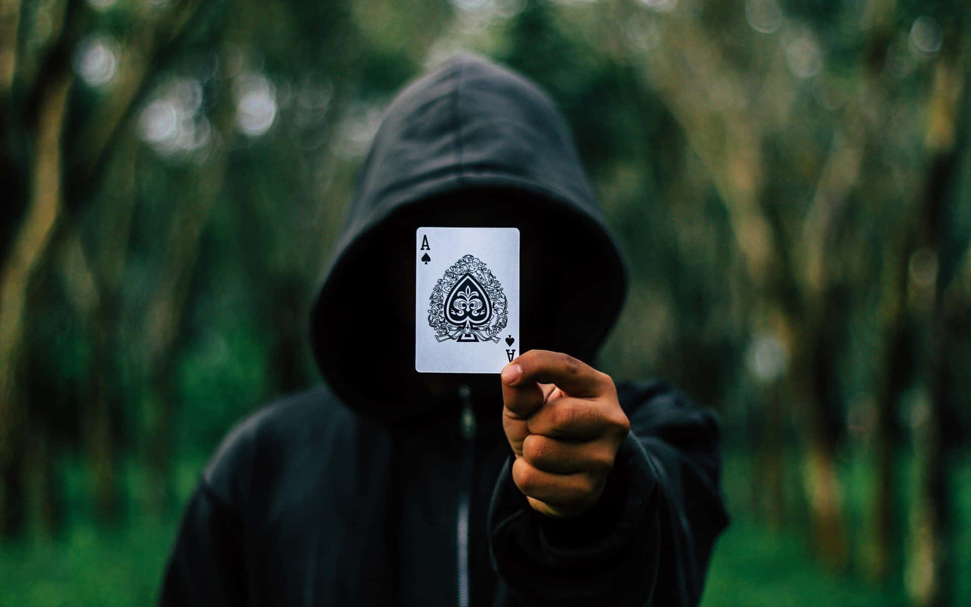 Mysterious Figure Holding Aceof Spades Wallpaper