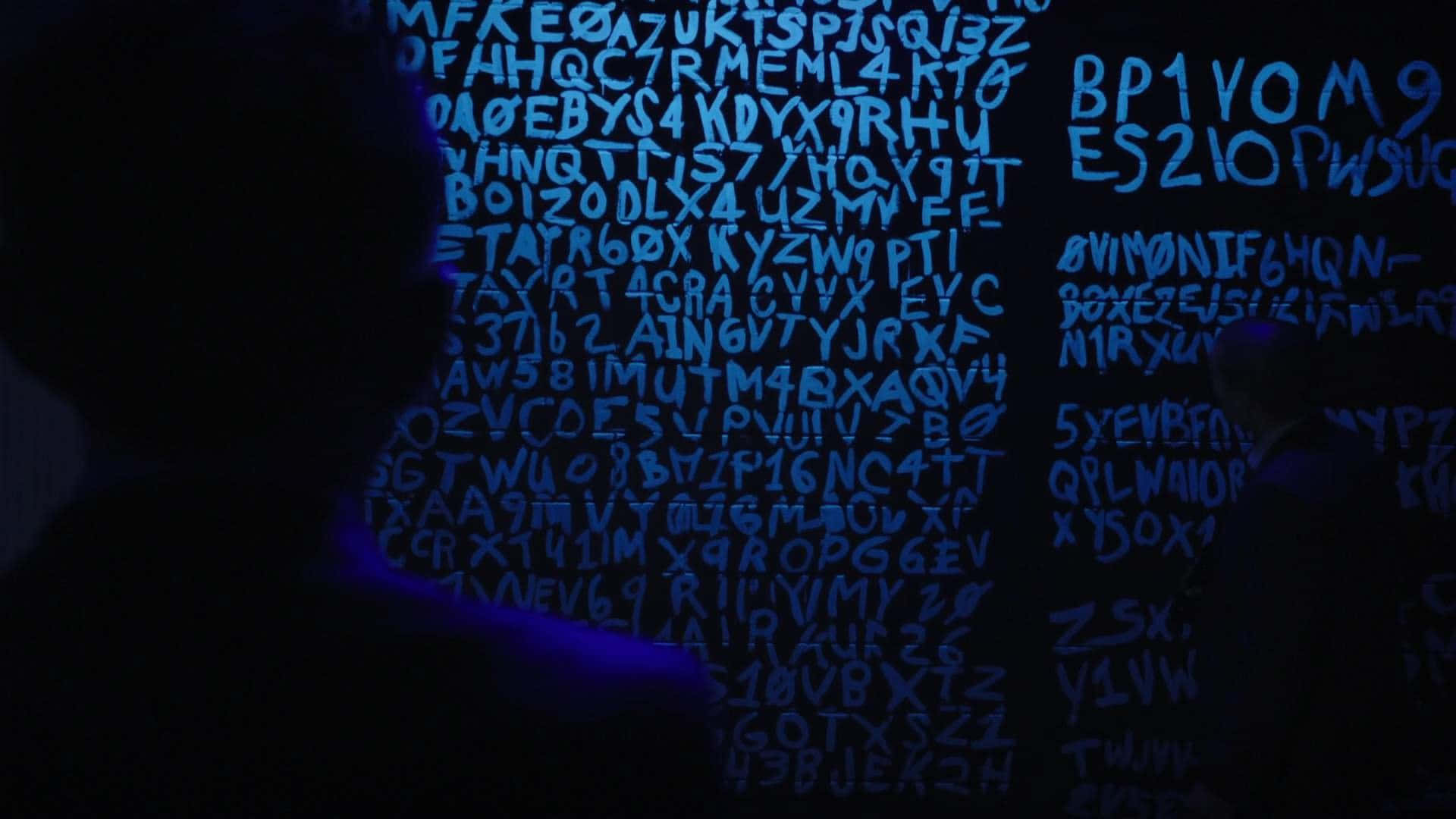 Einmann Steht Vor Einer Blauen Wand Mit Buchstaben Darauf Geschrieben.