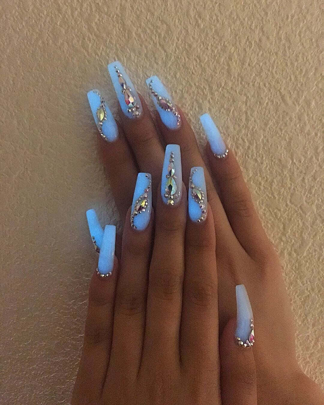 A Woman's Nails With Blue And White Glitter
