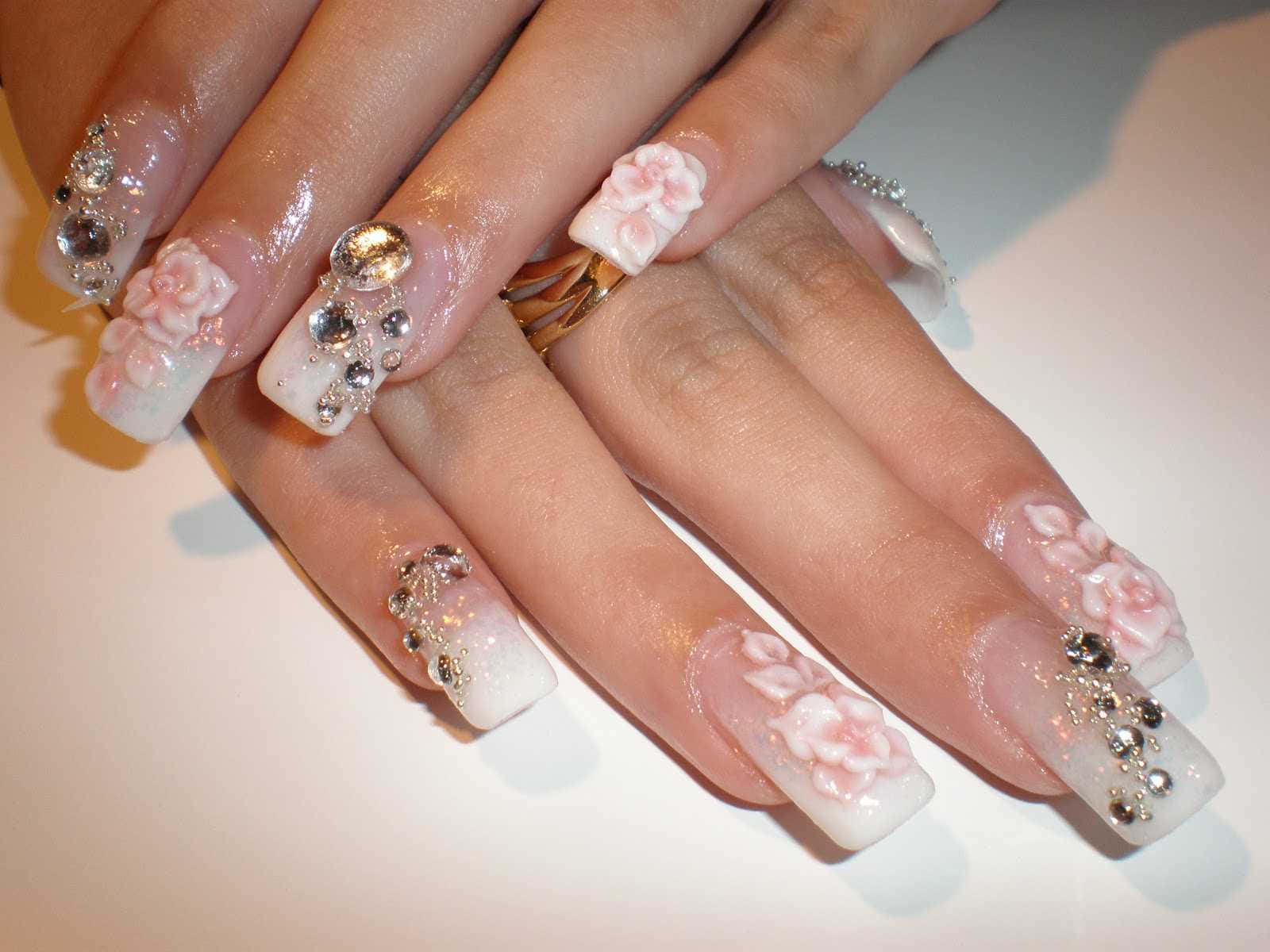 A Woman's Nails With Flowers And Diamonds