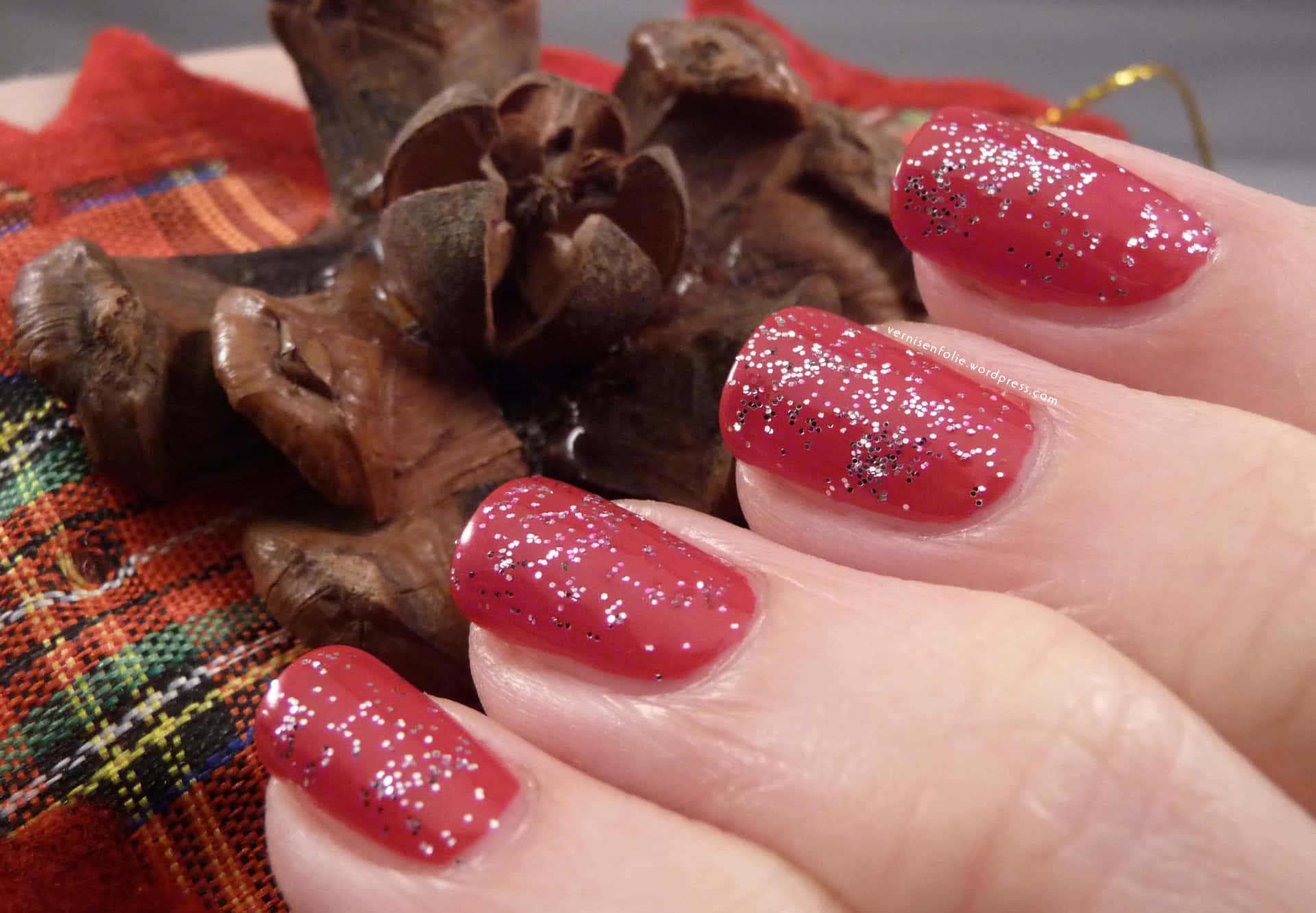 A Woman Holding A Red Nail Polish With Glitter