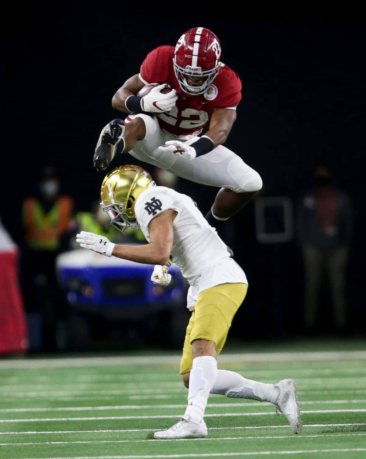 Download Najee Harris Athletic Hurdle Over Defender Wallpaper ...