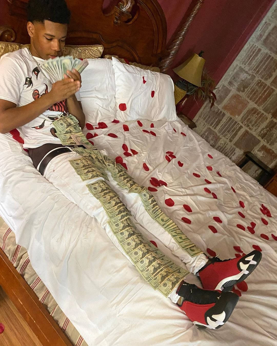 A Man Is Laying On A Bed With Money On His Bed Wallpaper