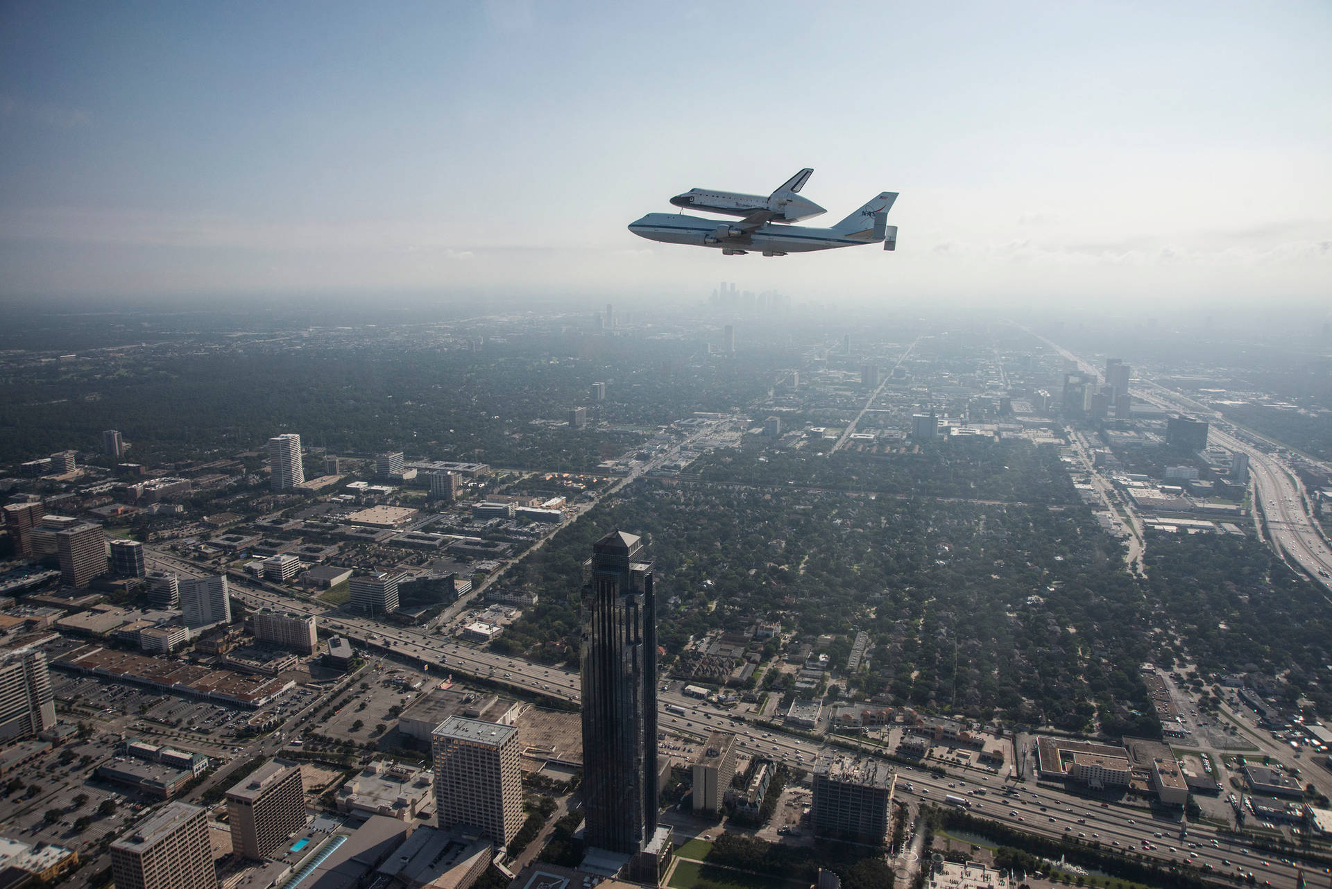 NASA Houston flyvende fly i grå himmeltapet Wallpaper