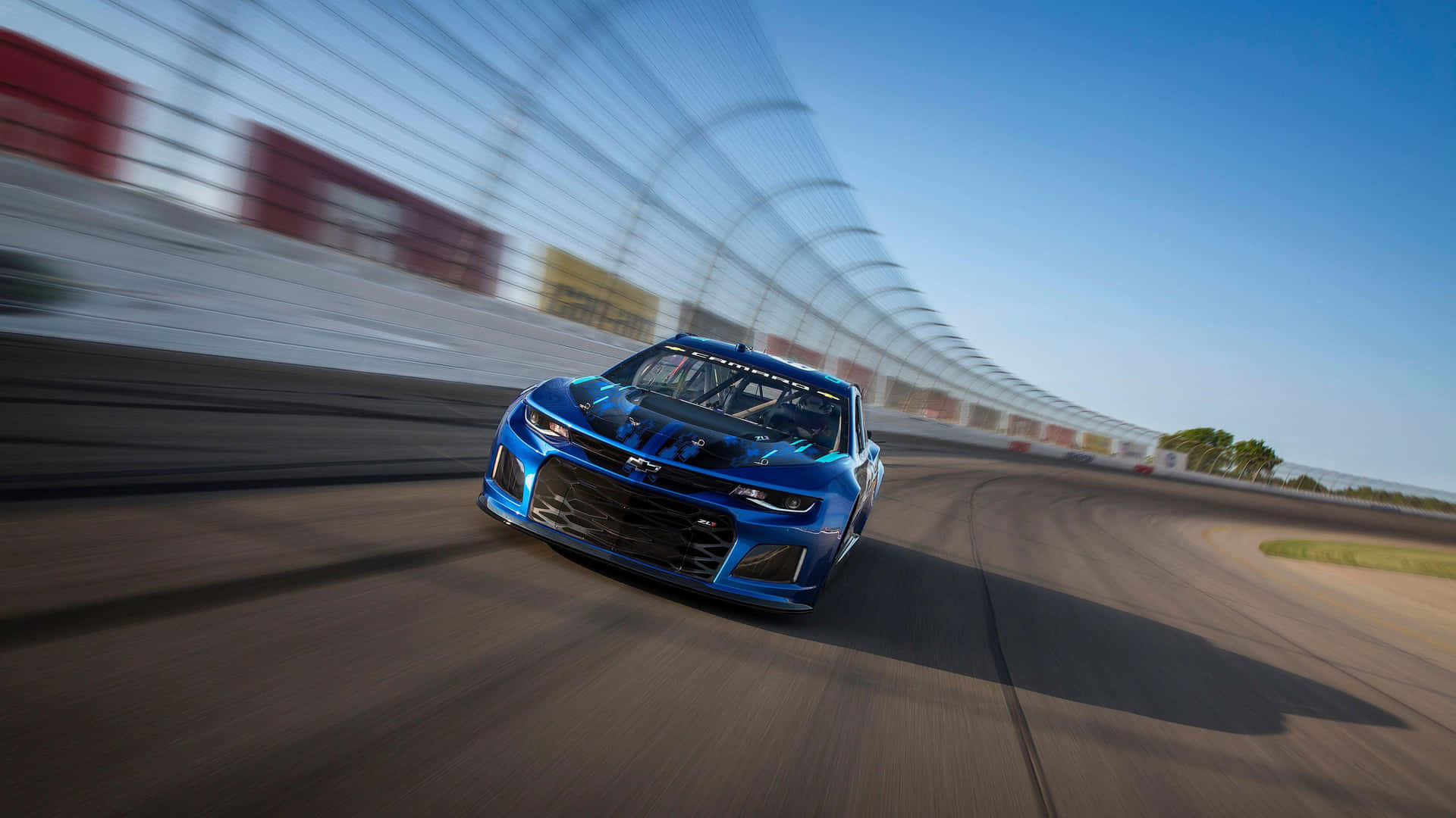 A Blue Nascar Camaro Is Driving On A Track