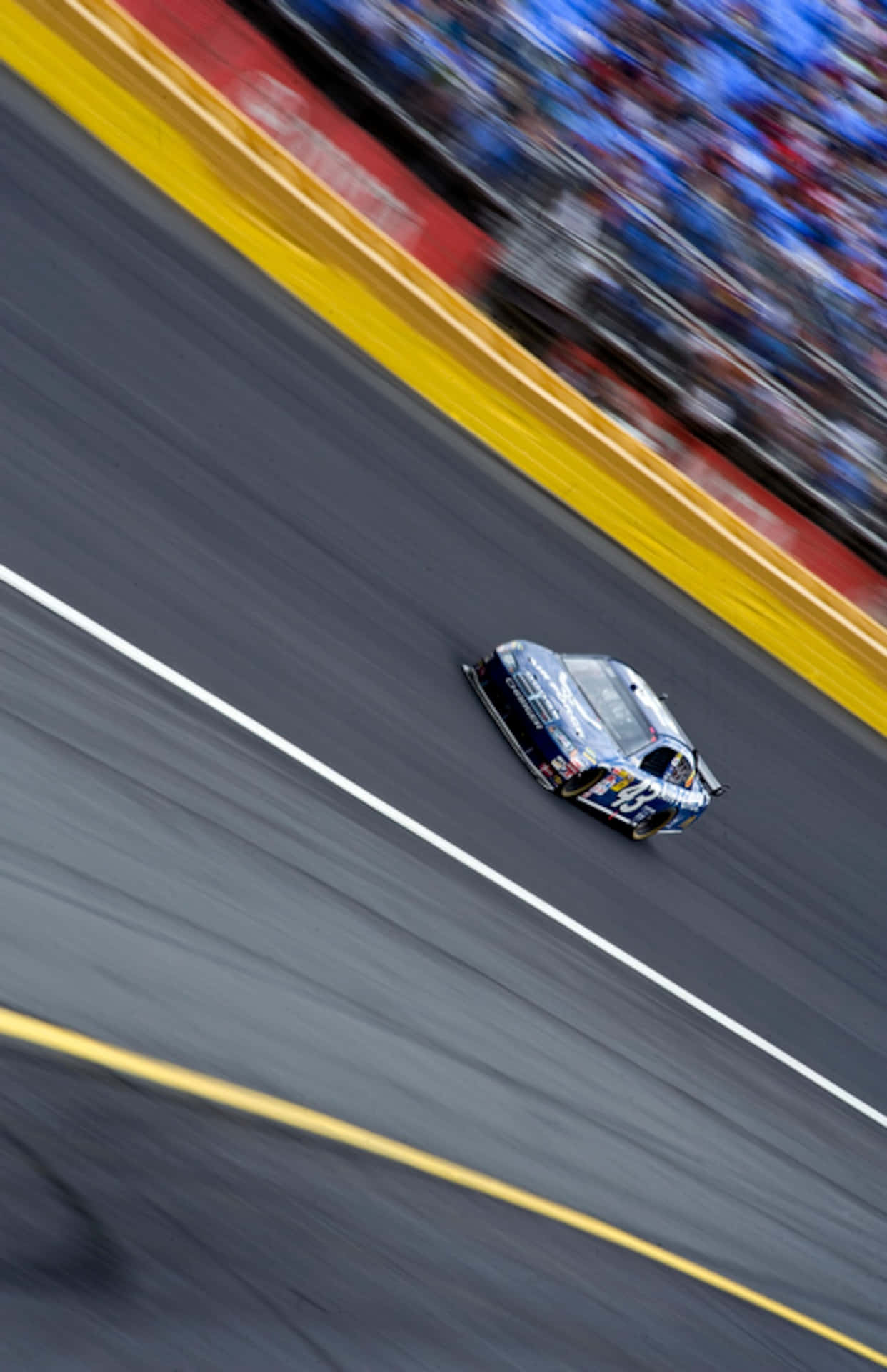 En NASCAR-bil kører på en bane Wallpaper