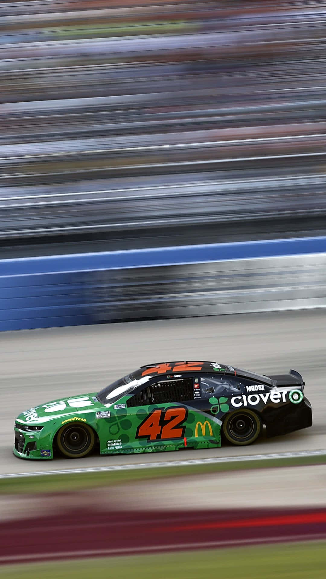 En grøn NASCAR bil kører på en bane Wallpaper
