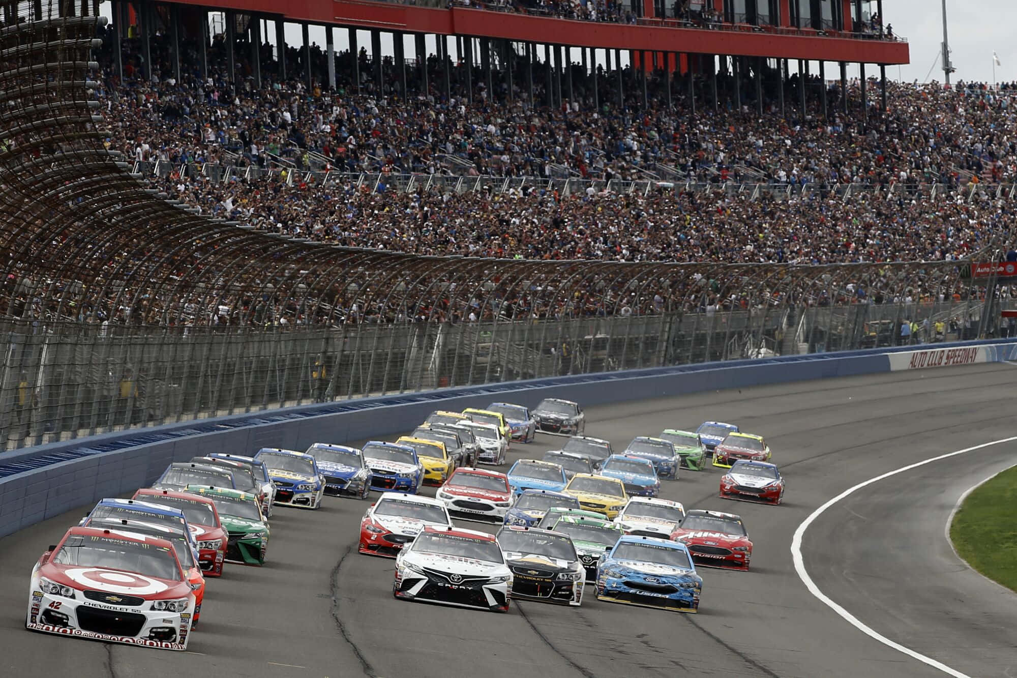 Nascar Drivers Race Down The Track During A Race