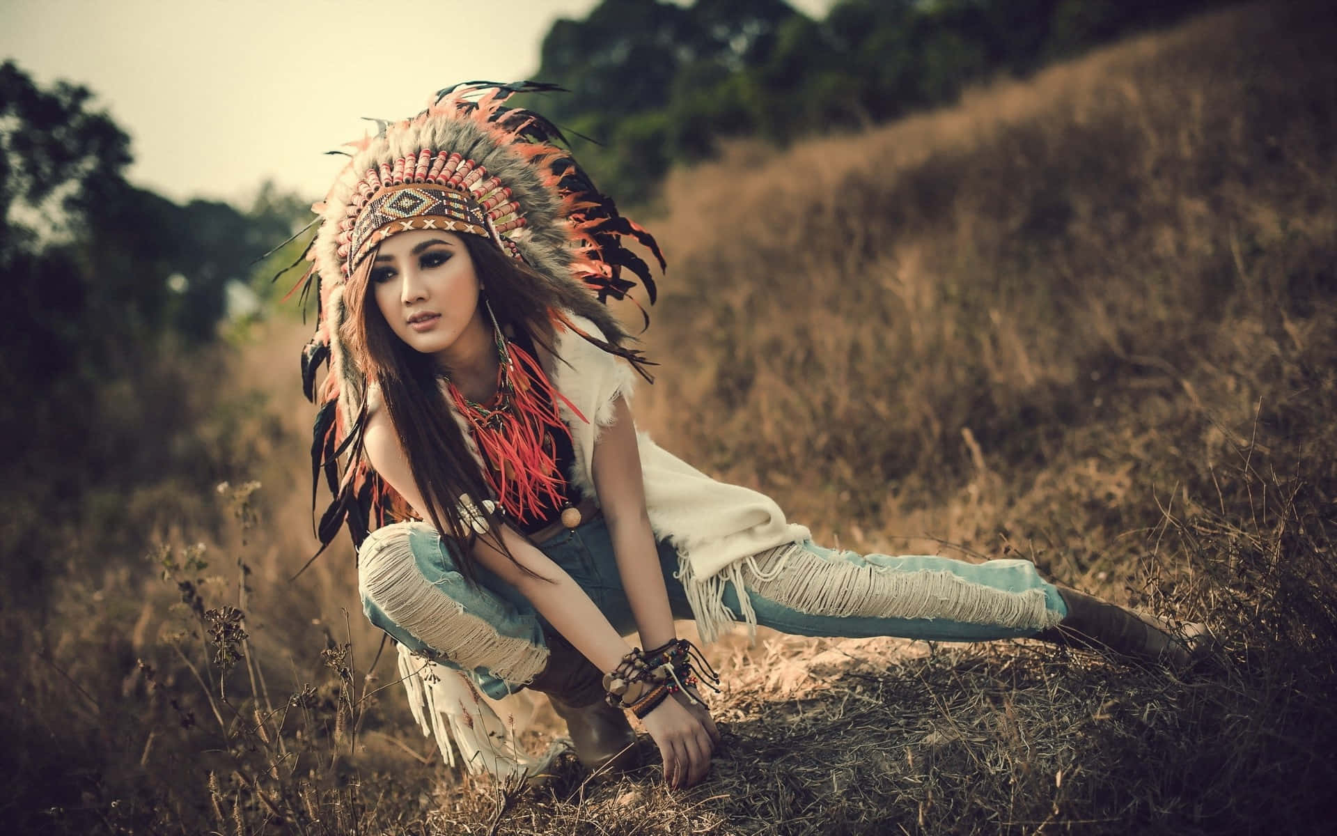 Enkvinna Med En Amerikansk-indiansk Huvudbonad Poserar På En Äng Wallpaper