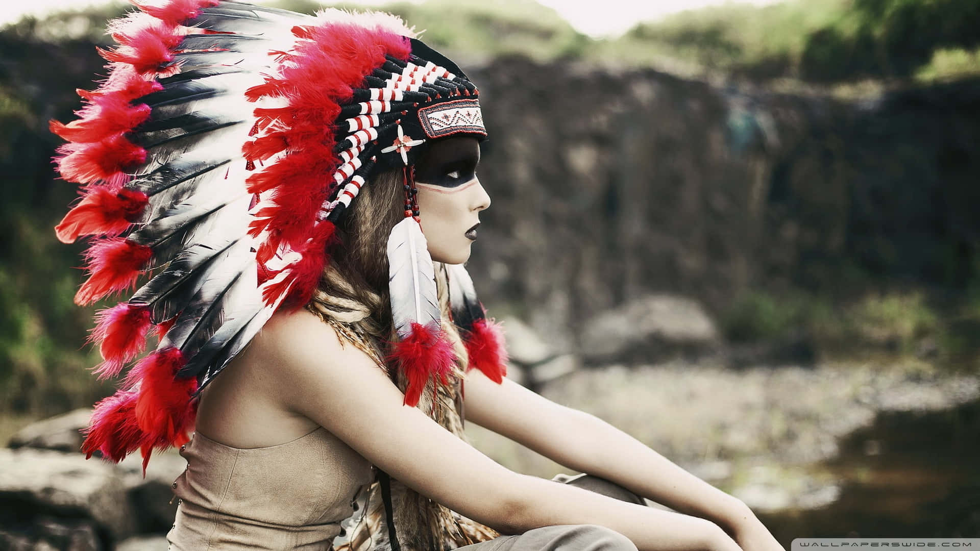 Download A Woman Wearing A Native American Headdress Wallpaper