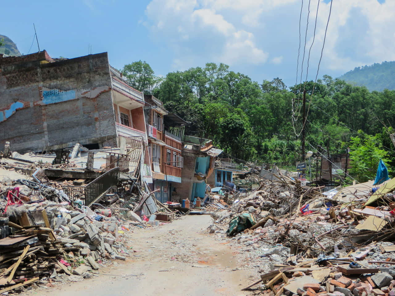 a road with debris and a house in the background