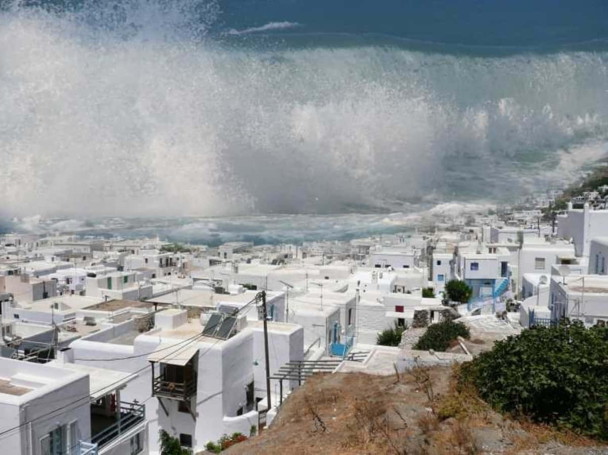 A Large Wave Crashes Into A White Building