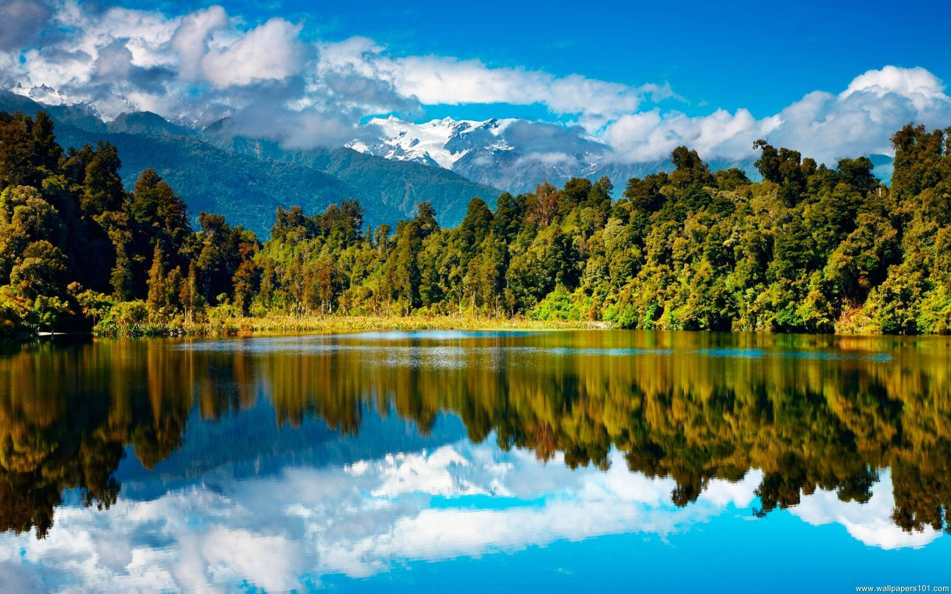 A tranquil view of nature by a calm lake and clear blue sky Wallpaper