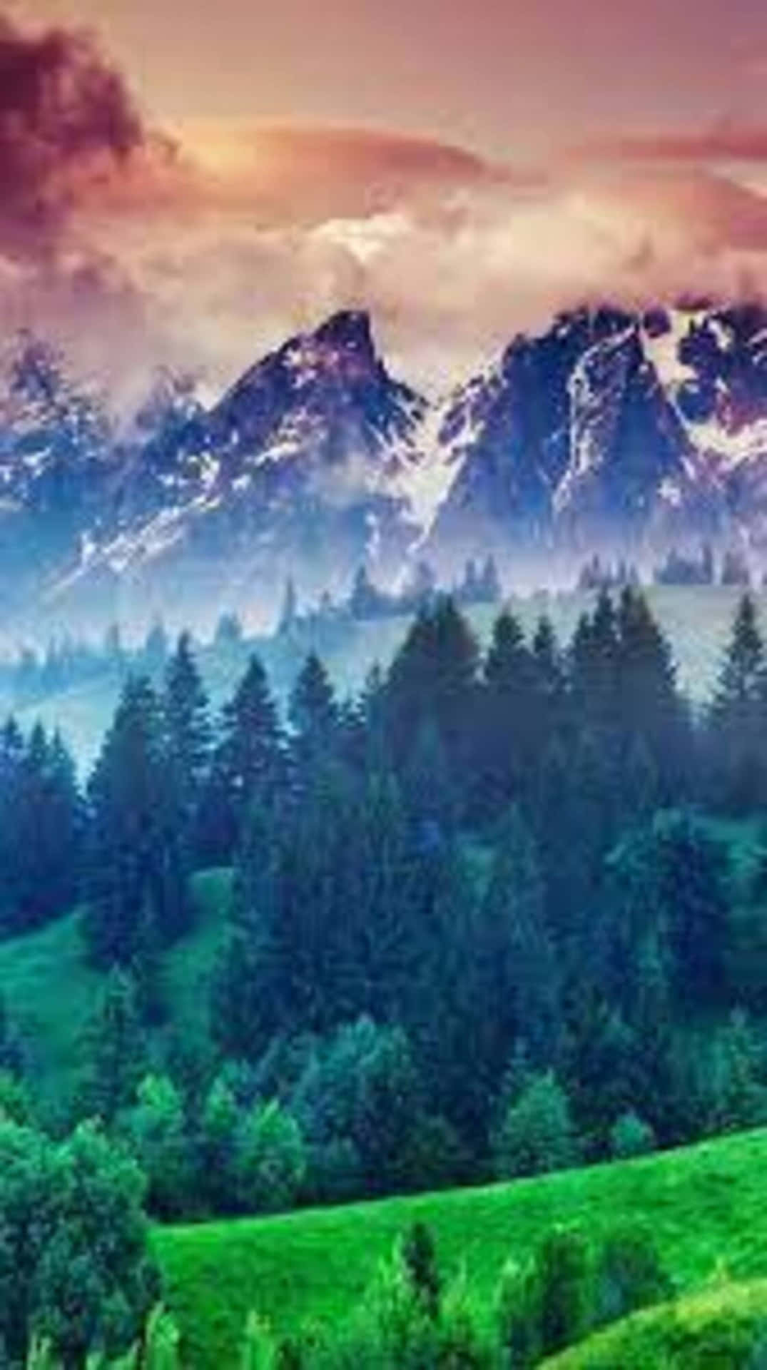 A Green Field With Mountains And Trees Wallpaper