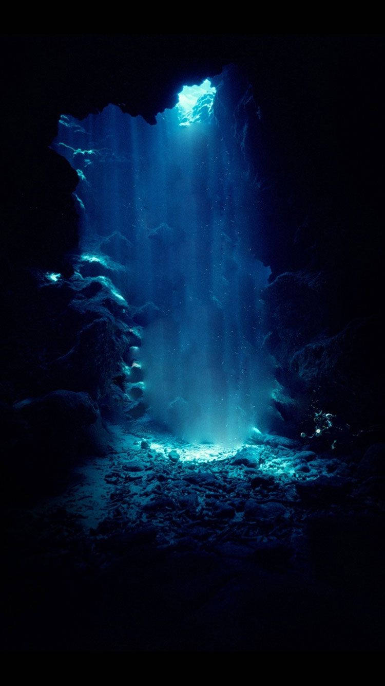 Unaluce Blu Brilla Attraverso Una Grotta Sfondo