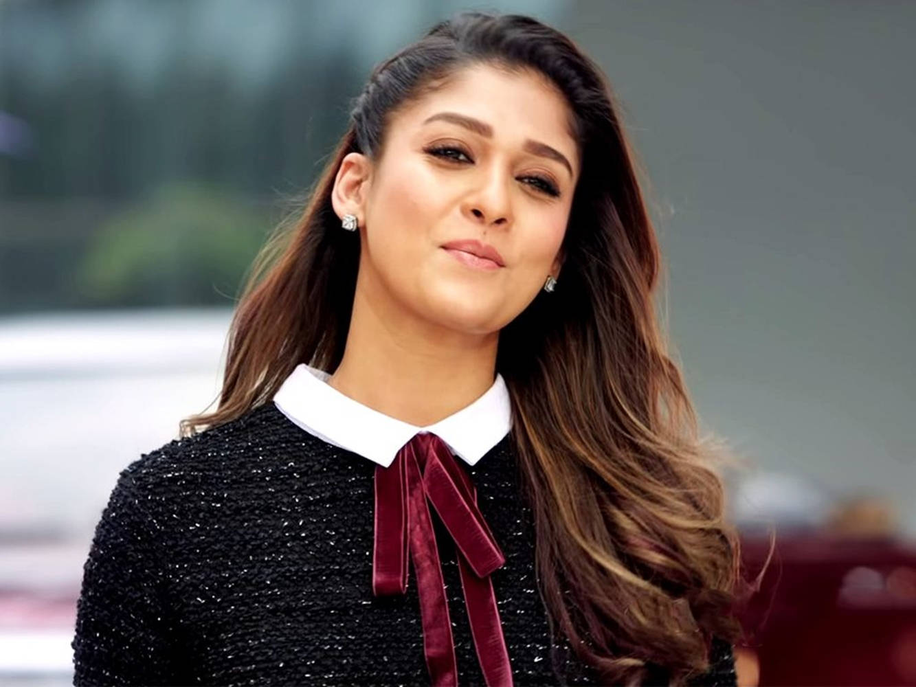 Captivating Nayanthara in a Stylish Black Ensemble with a Red Tie Wallpaper