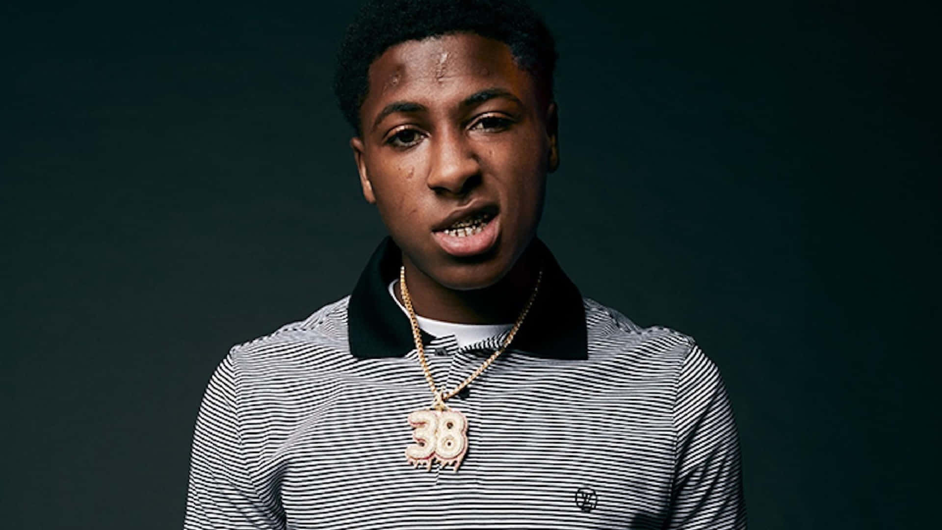 Nba Youngboy strides forward with a determined look