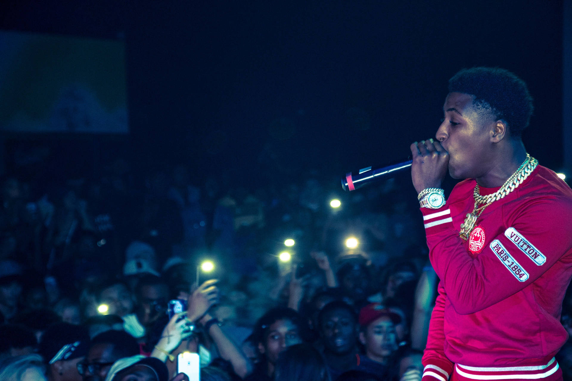 NBA Youngboy performs onstage in front of an excited crowd Wallpaper