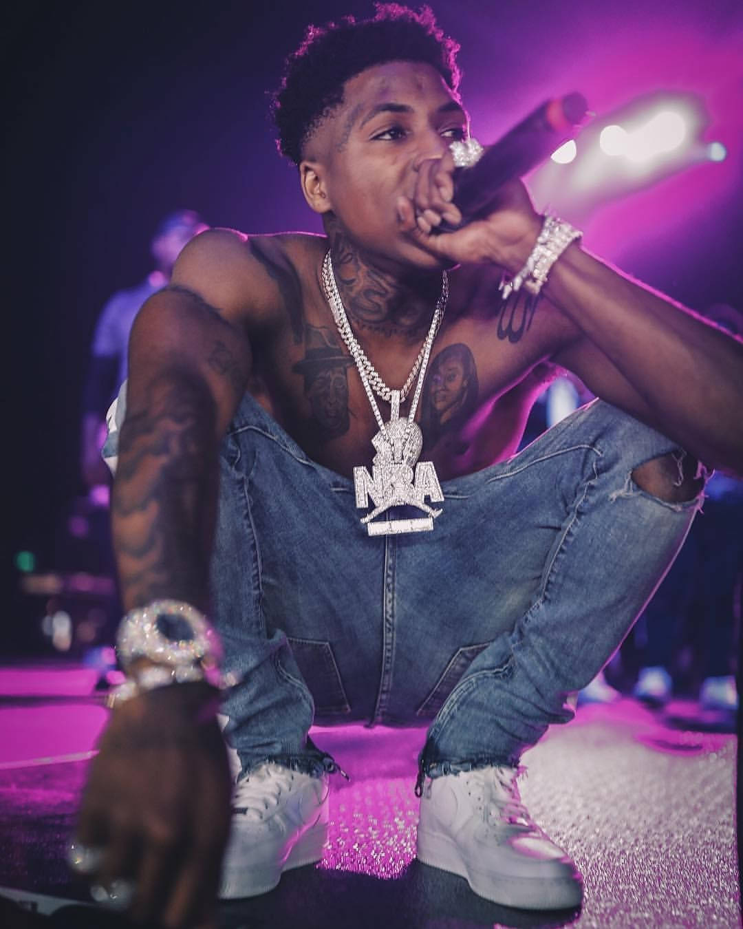 NBA Youngboy appearing on purple neon lights stage Wallpaper