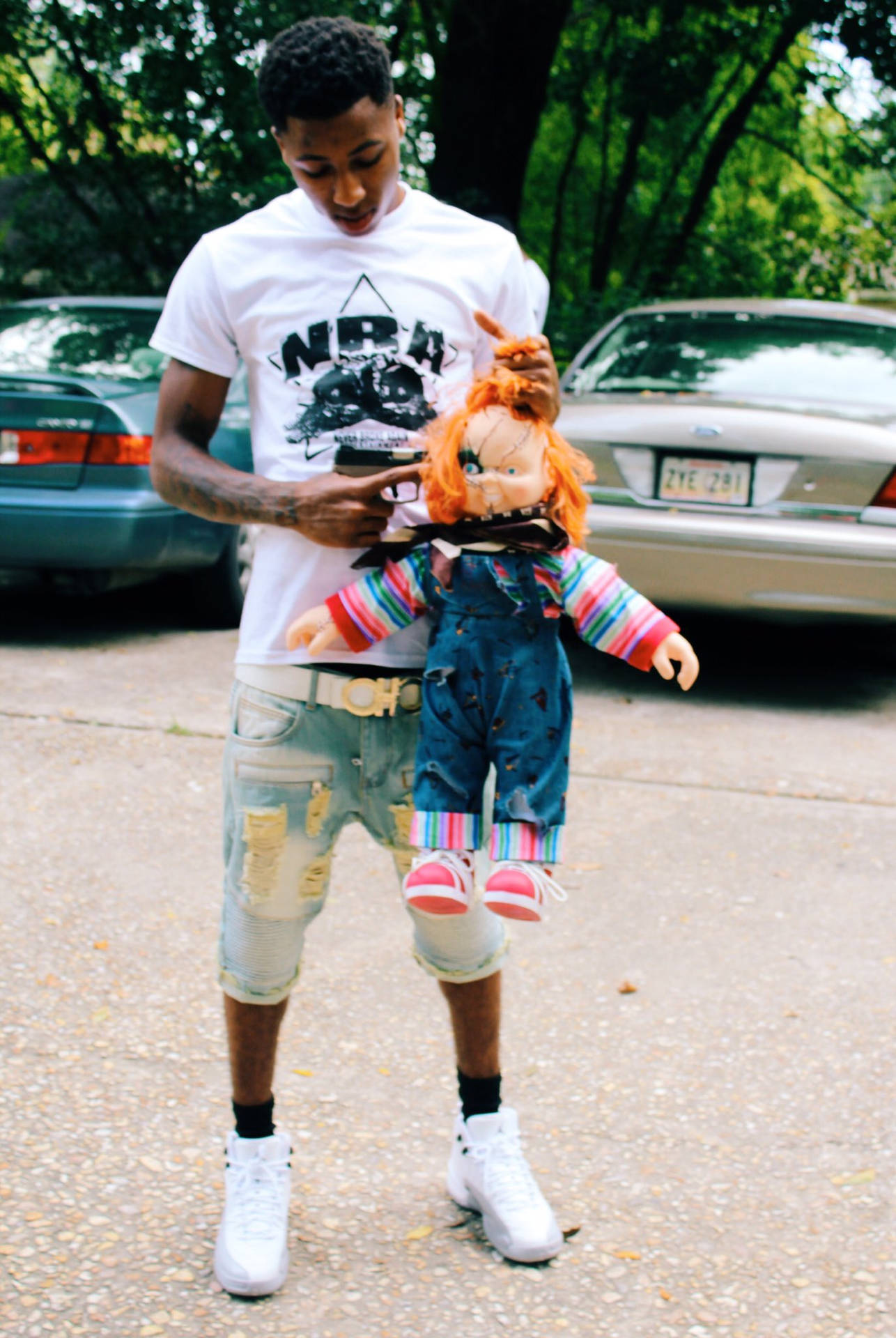 Nba Youngboy poses with signature Chucky doll Wallpaper