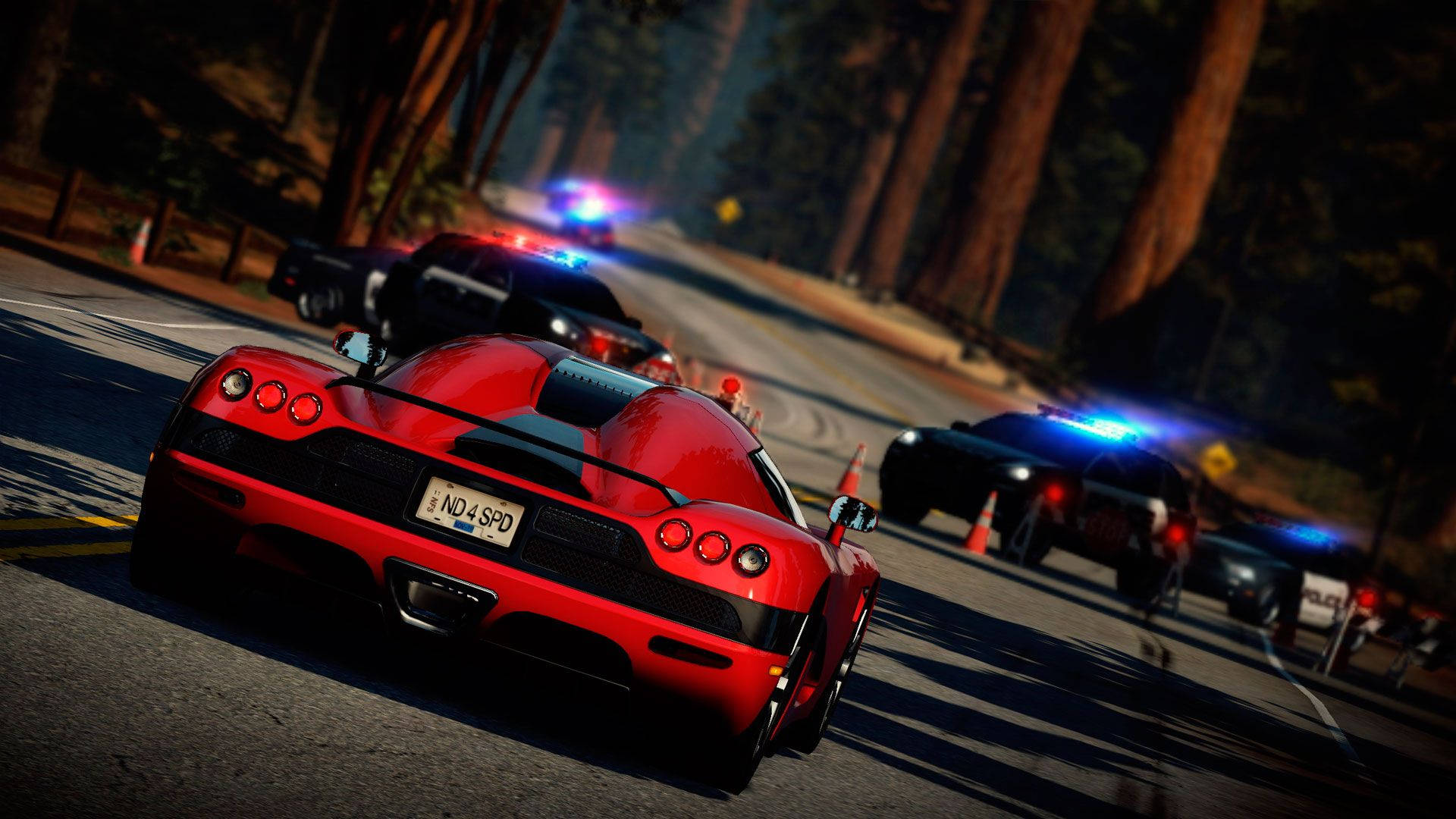 A Red Car Driving Down A Road With Police Cars Wallpaper