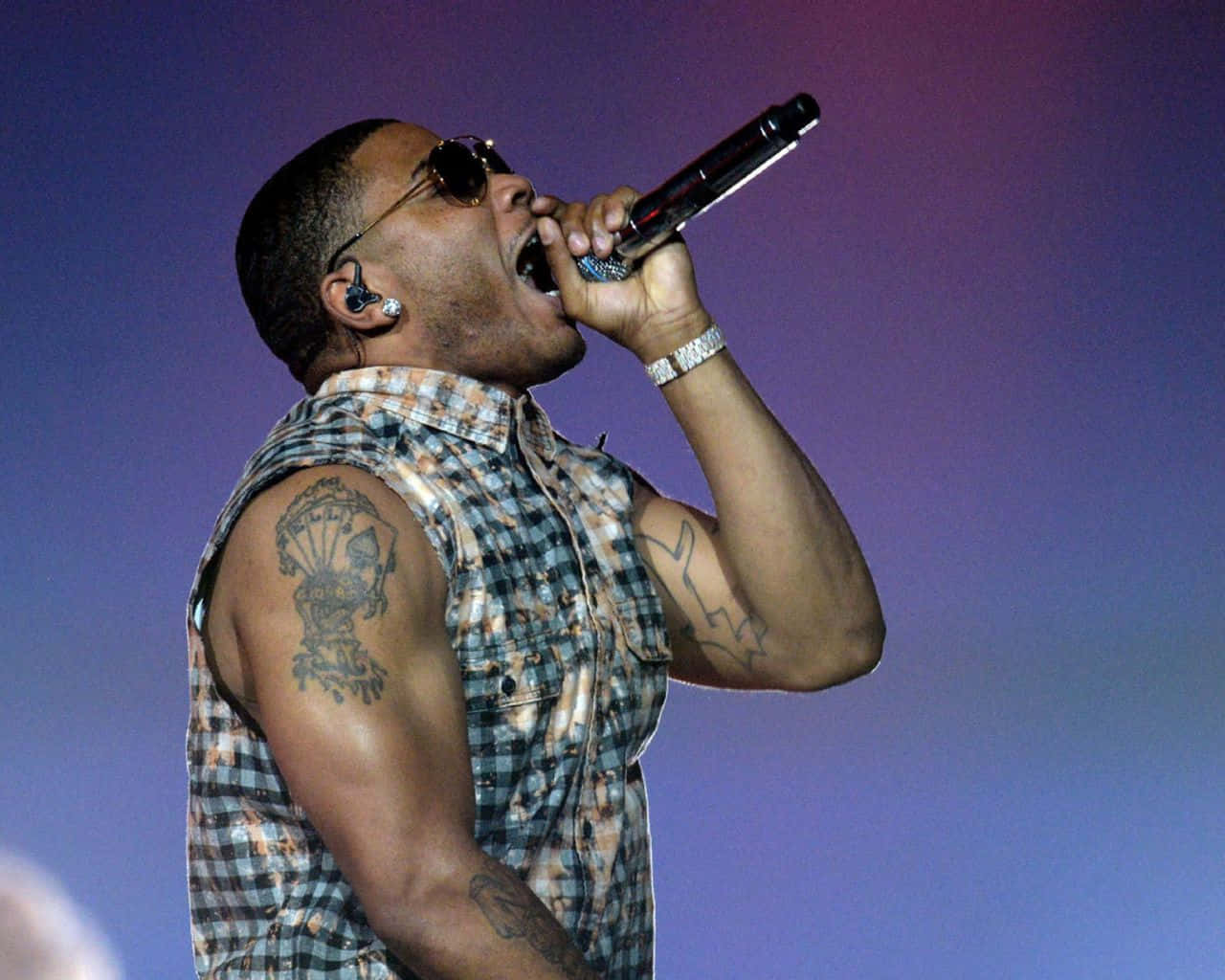 Nelly holder et mikrofon og synger under et koncert. Wallpaper