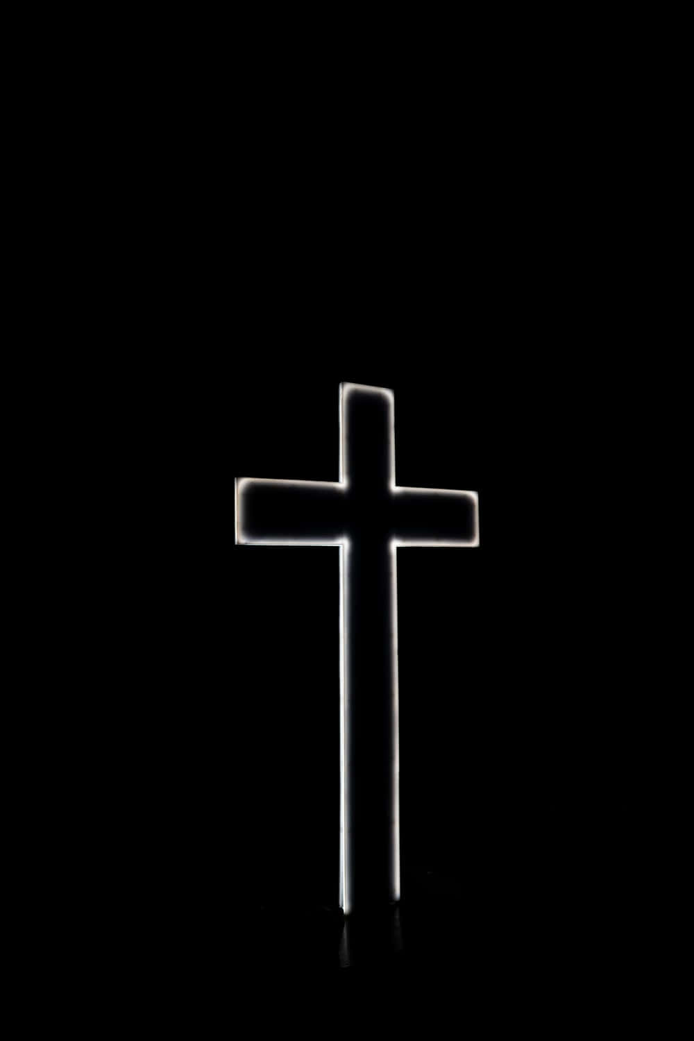 A Cross Is Lit Up In The Dark Wallpaper