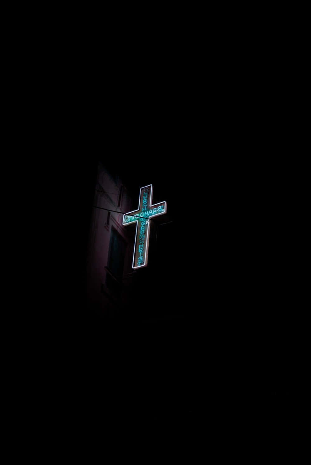A Cross Is Lit Up In The Dark Wallpaper