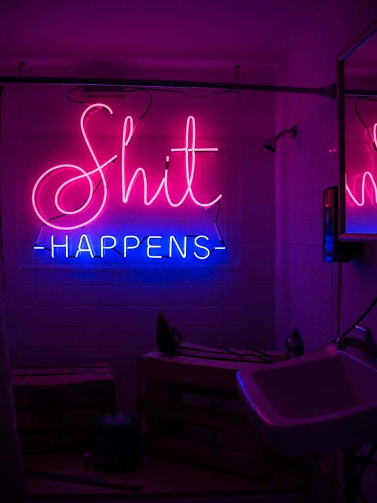 Et neon skilt, der siger 'shit sker' på et badeværelse. Wallpaper