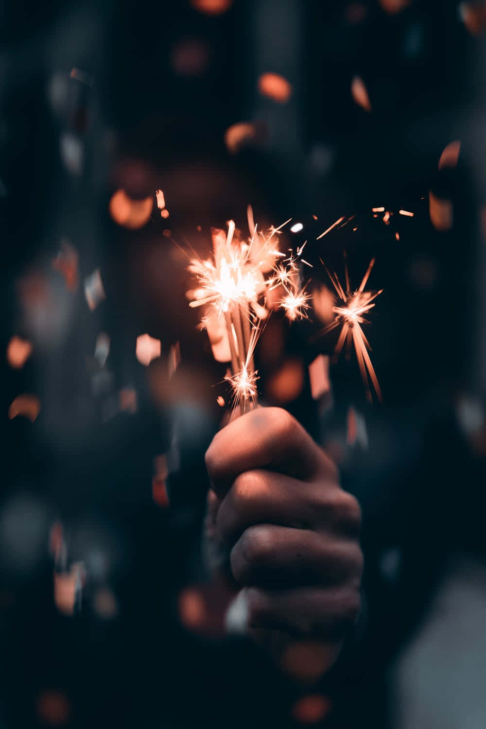 A Person Holding A Sparkler In Their Hand Wallpaper