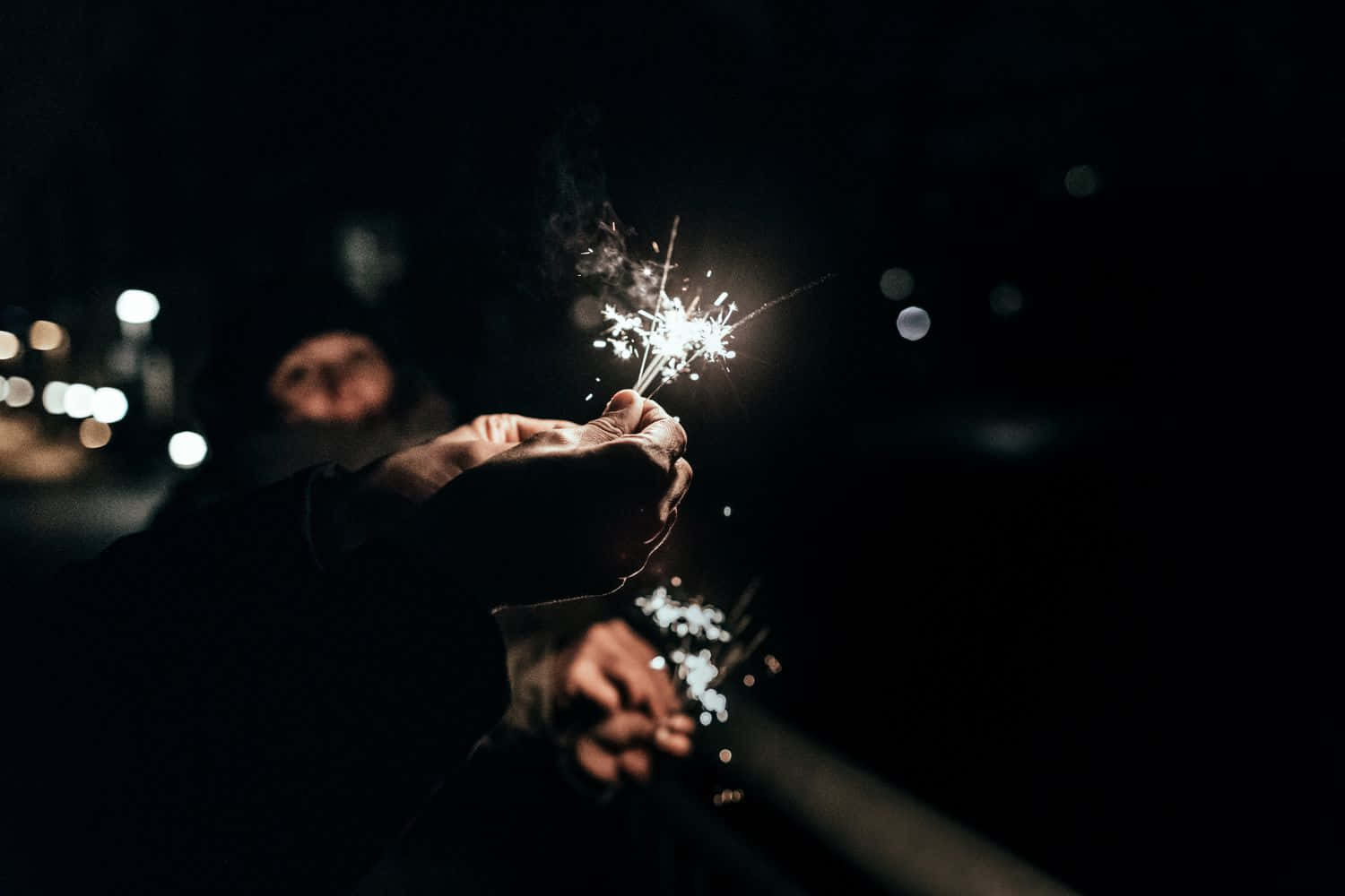 A Person Holding A Sparkler In The Dark