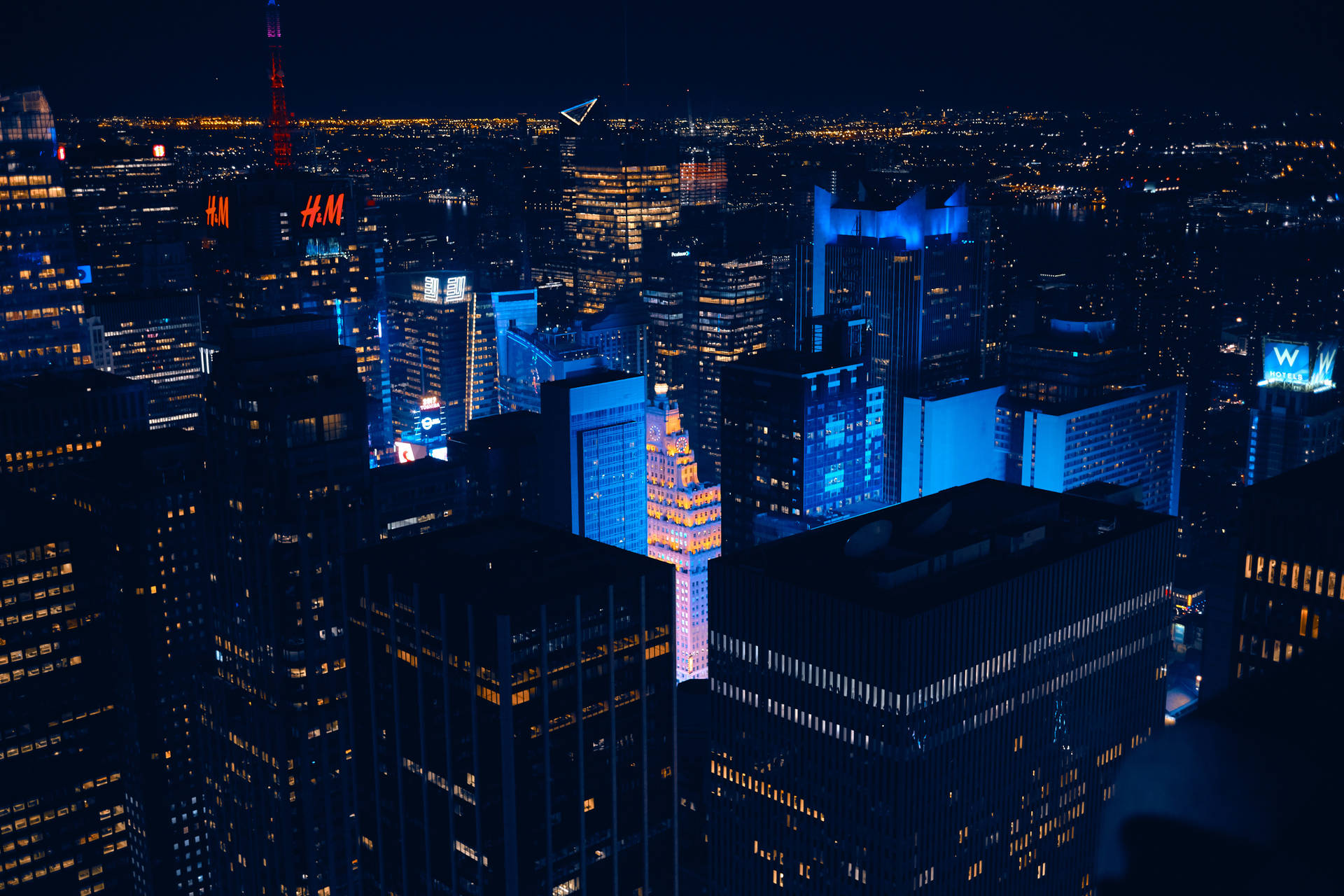 The bustling city of New York glows with blue light. Wallpaper
