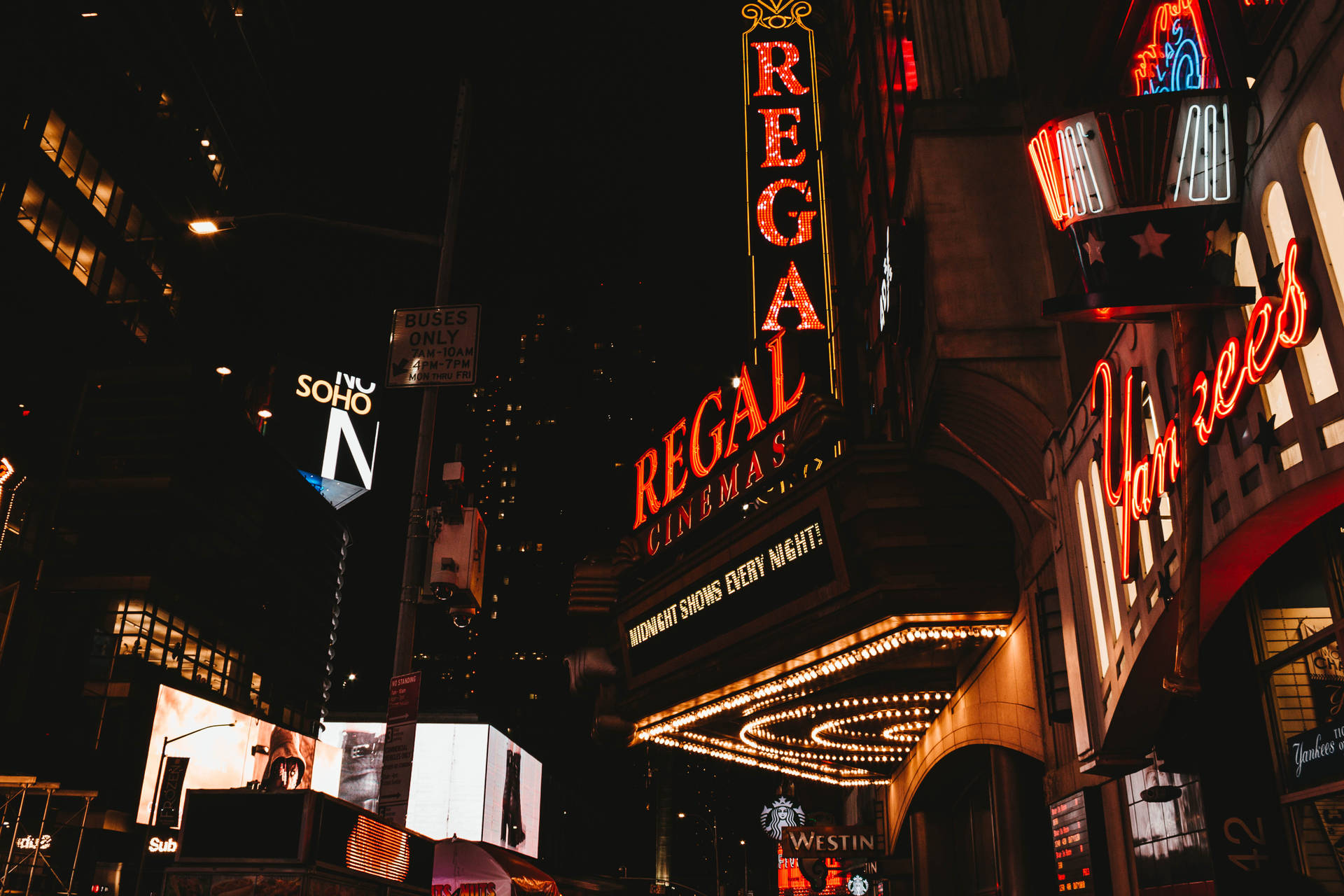 Vistanocturna De La Ciudad De Nueva York Frente Al Regal Cinema Fondo de pantalla