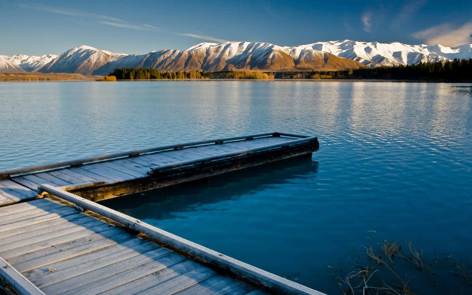 A Wooden Dock With Mountains In The Background